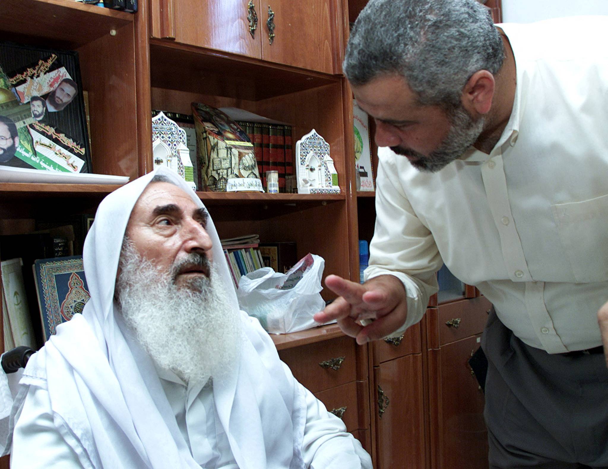 مؤسس حركة «حماس» الشيخ أحمد ياسين يتحدث مع مدير مكتبه آنذاك والزعيم اللاحق للحركة إسماعيل هنية في صورة تعود لعام 2002 (رويترز)