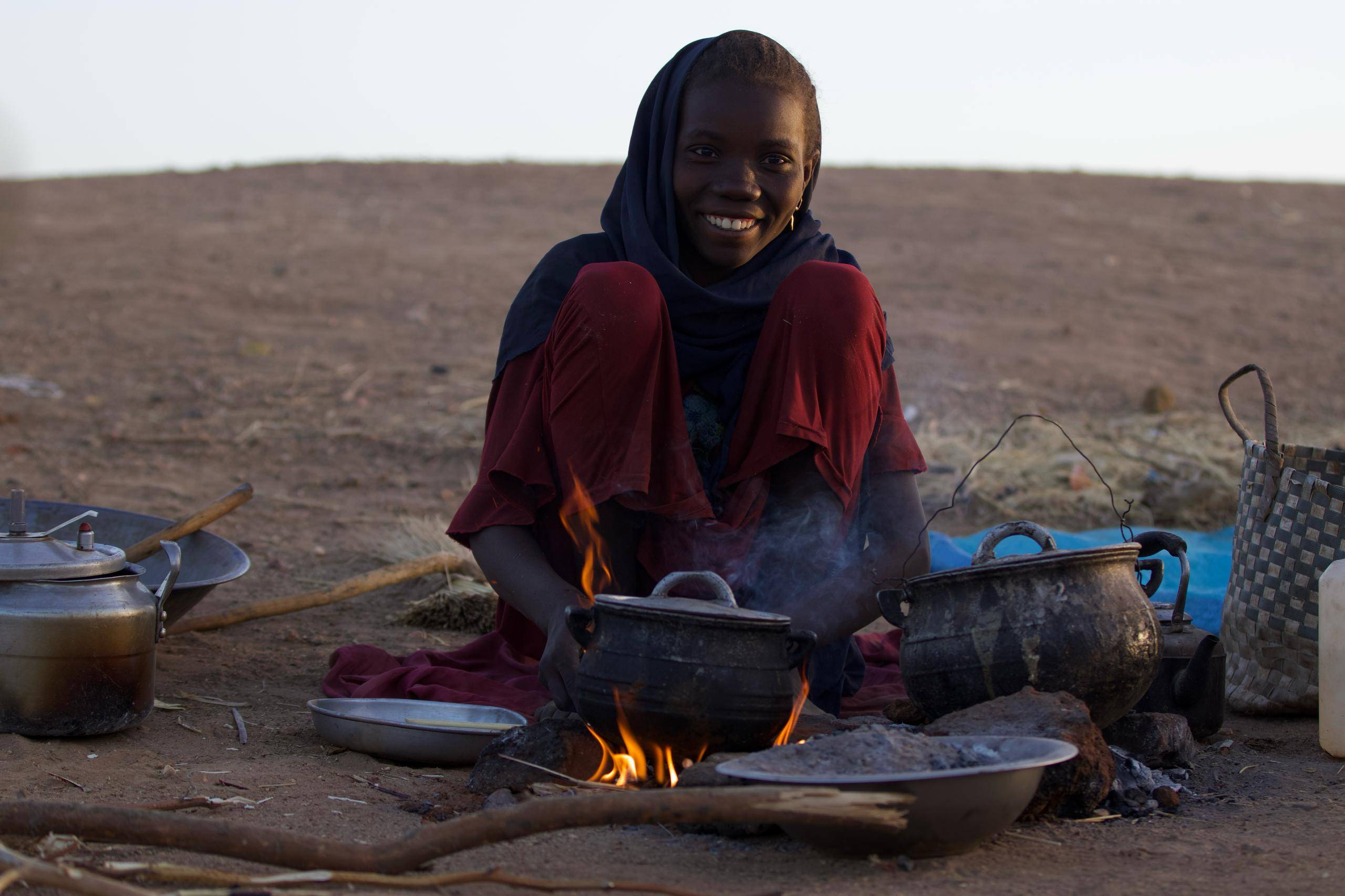 نازحة من الفاشر تجهز الطعام في العراء (المنسقية العامة للنازحين واللاجئين بدارفور)