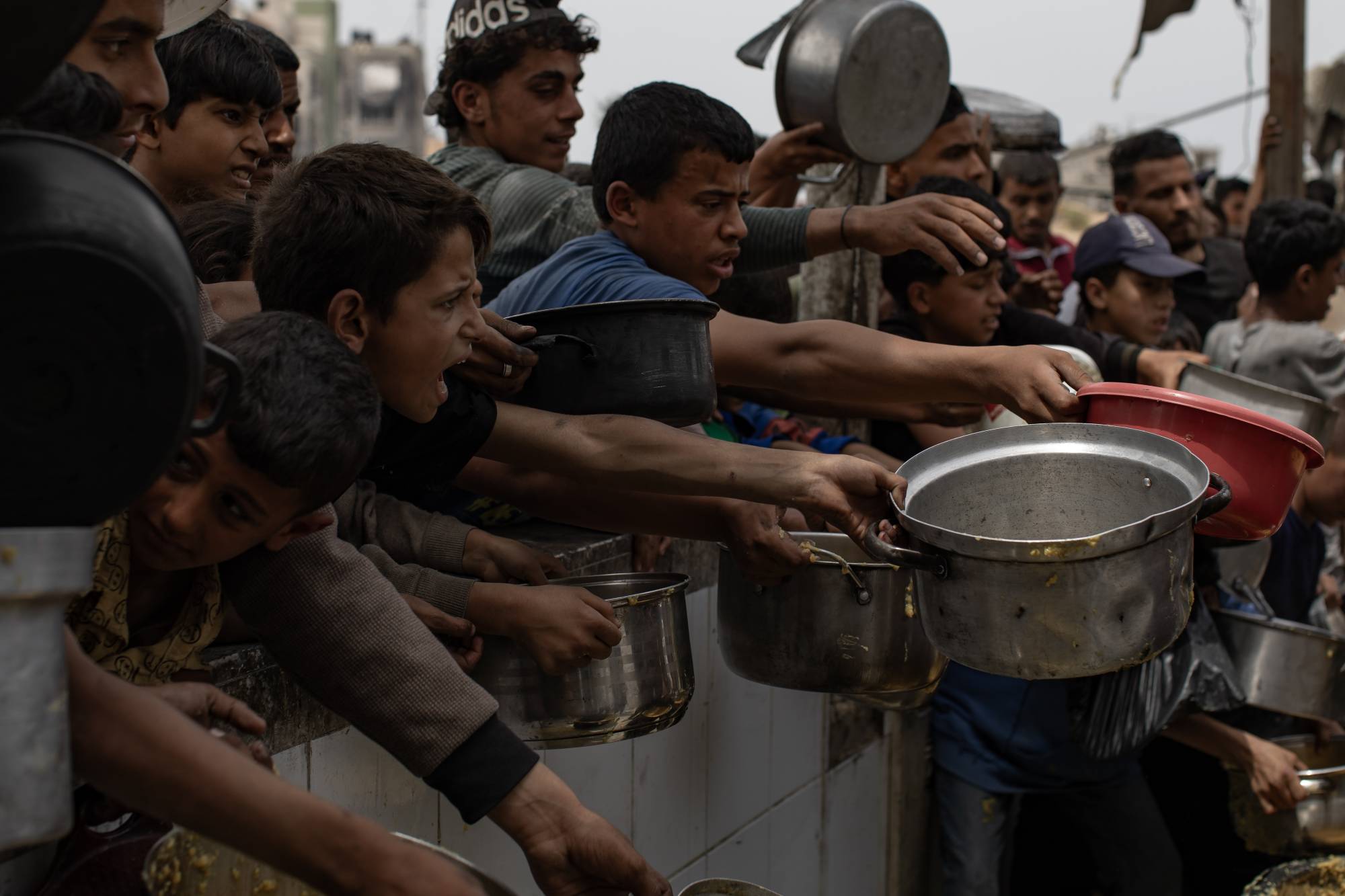 نازحون فلسطينيون في طابور للحصول على حصة من الطعام من مطبخ خيري بجباليا في شمال قطاع غزة (إ.ب.أ)