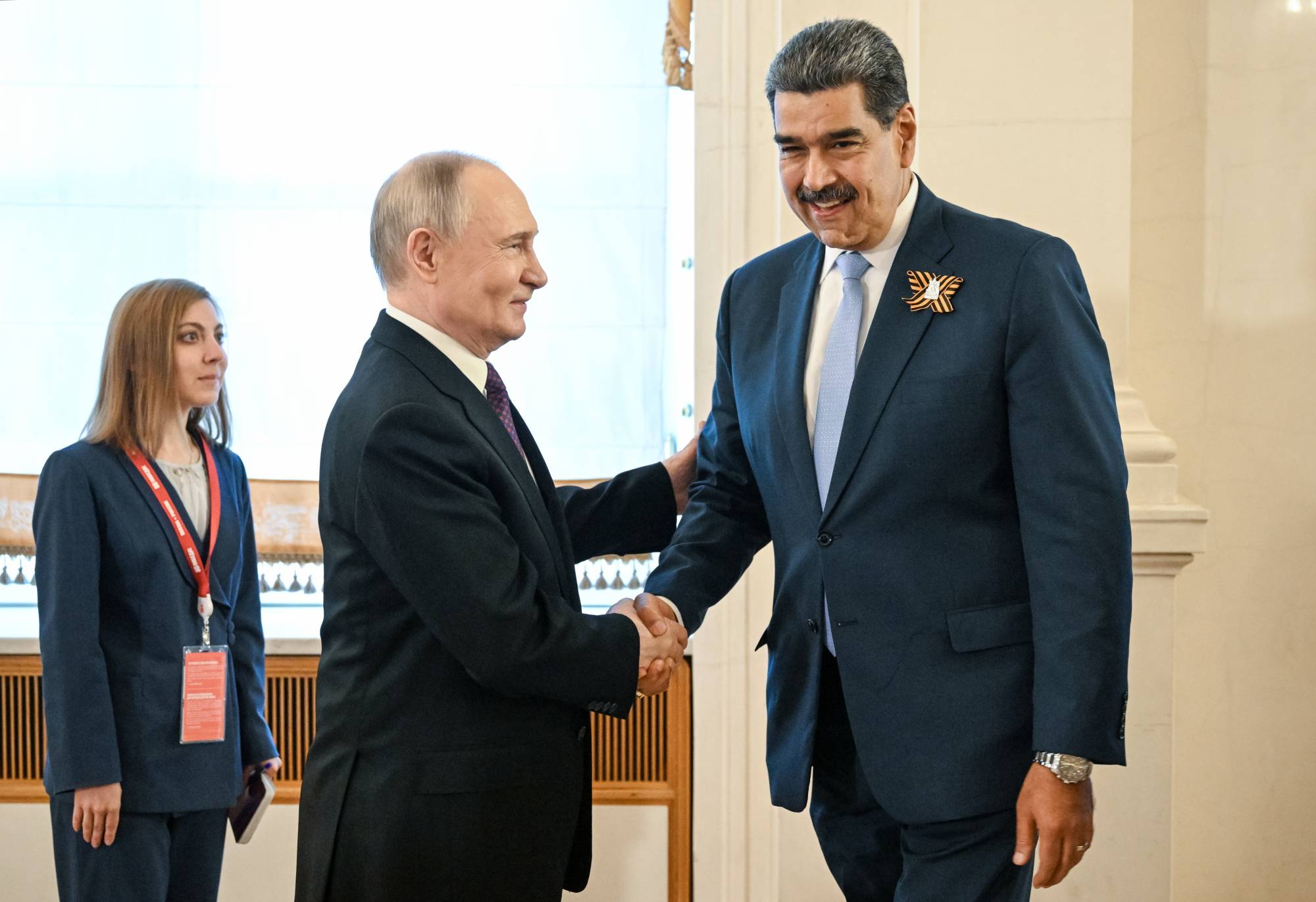 الرئيس الروسي فلاديمير بوتين (يسار) يرحب بالرئيس الفنزويلي نيكولاس مادورو في موسكو قبل احتفالات يوم النصر (إ.ب.أ)
