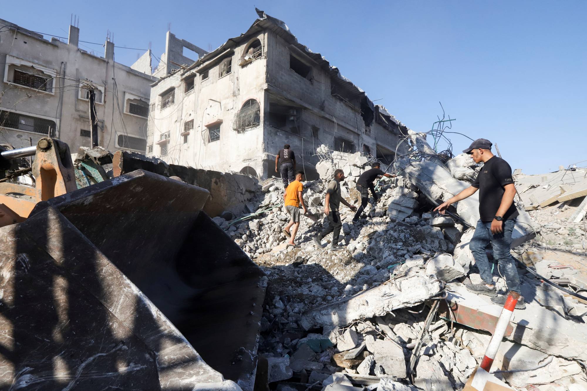 فلسطينيون يبحثون بين الأنقاض يوم الأربعاء عن ضحايا غارة إسرائيلية ليلية على موقع يؤوي نازحين بمدينة غزة (رويترز)