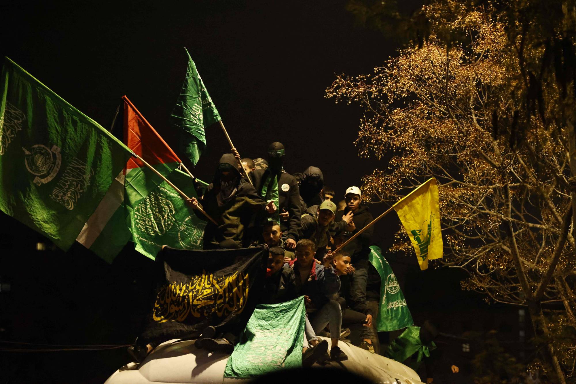 فلسطينيون يرفعون أعلاماً لـ«حماس» وفلسطين و«حزب الله» بالضفة الغربية يناير الماضي (رويترز)