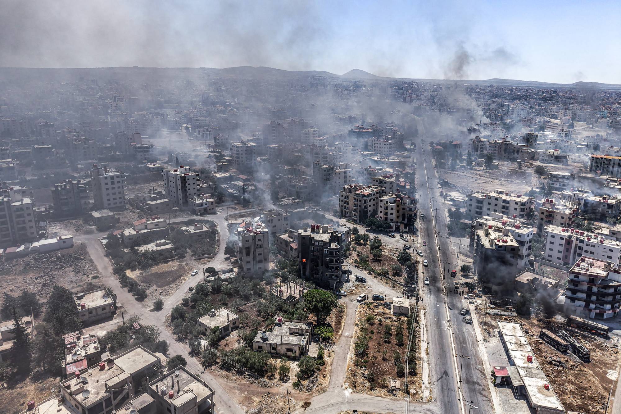 مدينة السويداء ودخان يتصاعد من منازل محترقة وسط اشتباكات بين مقاتلين من العشائر وفصائل درزية محلية جنوب سوريا في 19 يوليو الحالي (د.ب.أ)