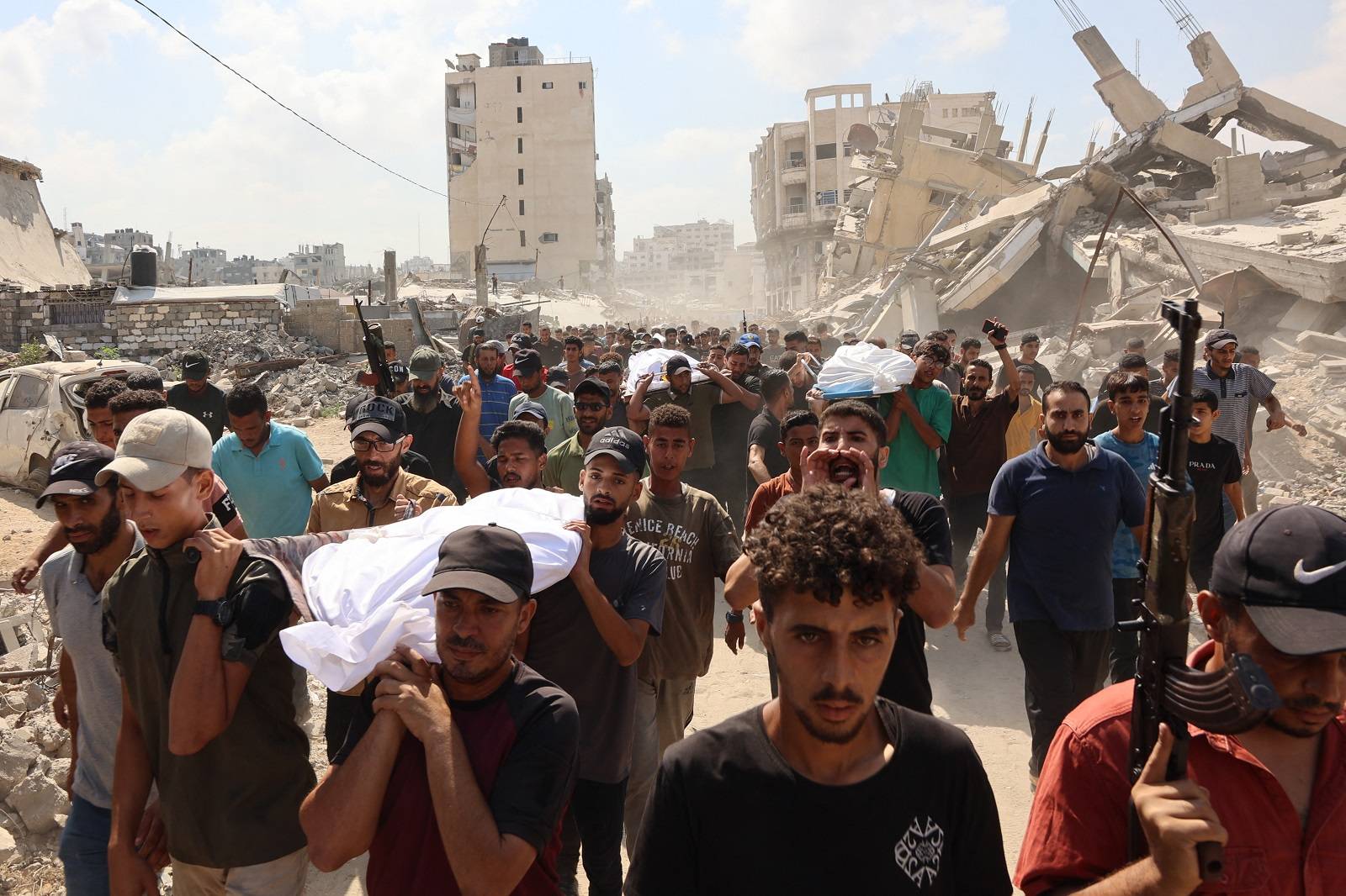يحمل مشيعون جثامين فلسطينيين قُتلوا الليلة الماضية في غارة إسرائيلية جنوب قطاع غزة (أ.ف.ب)