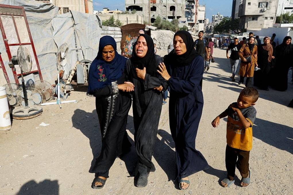 فلسطينيات ينتحبن خلال تشييع قتلى من منتظري المساعدات في مدينة غزة يوم الأربعاء (رويترز)