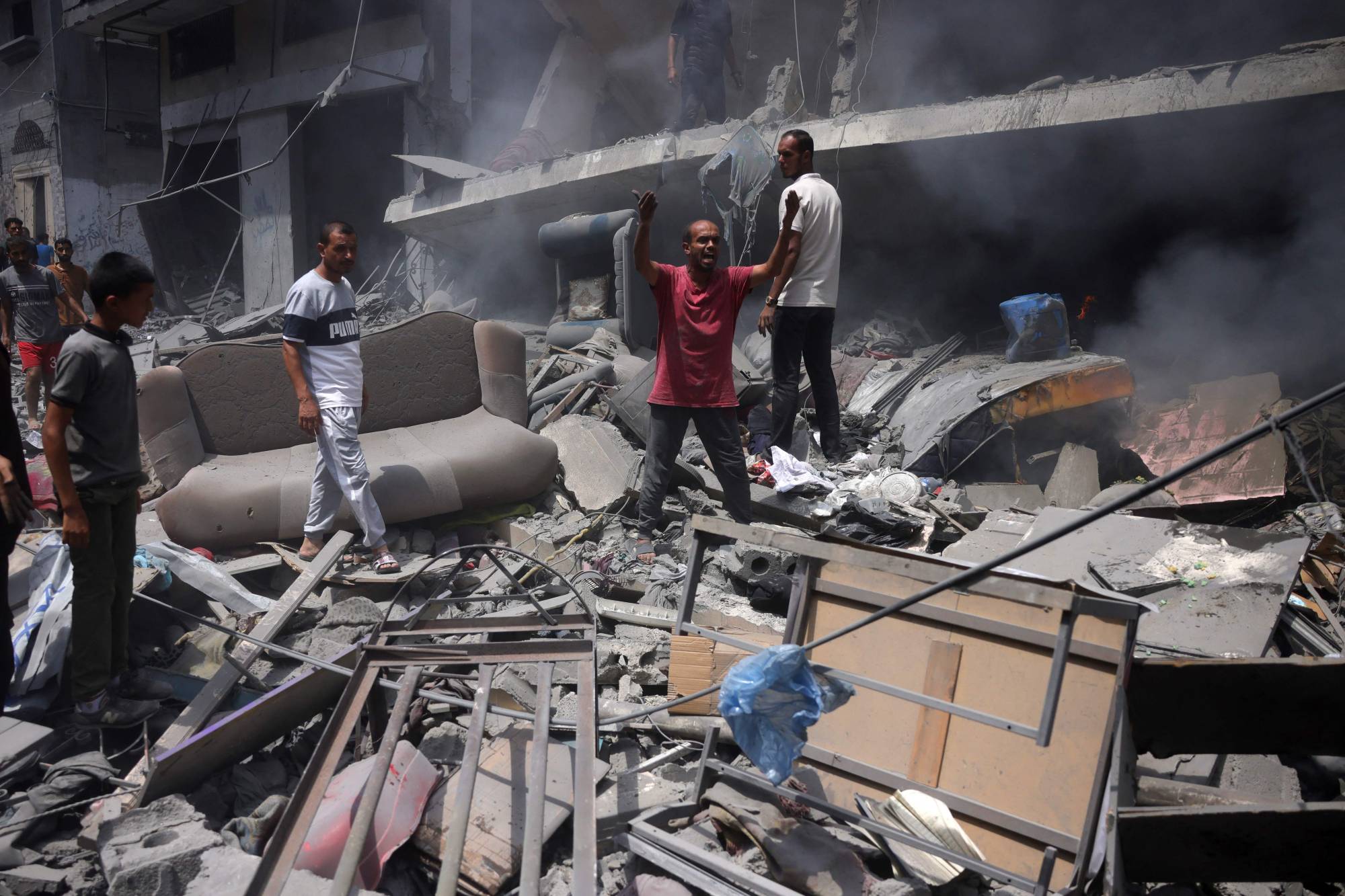 فلسطينيون يعاينون الدمار الذي أحدثته غارة إسرائيلية على حي الزيتون بجنوب مدينة غزة الجمعة (أ.ف.ب)