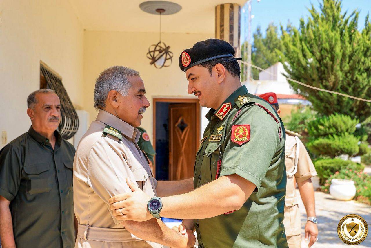صدام يصافح رئيس أركان «الجيش الوطني» عبد الرازق الناظوري (رئاسة أركان القوات البرية)