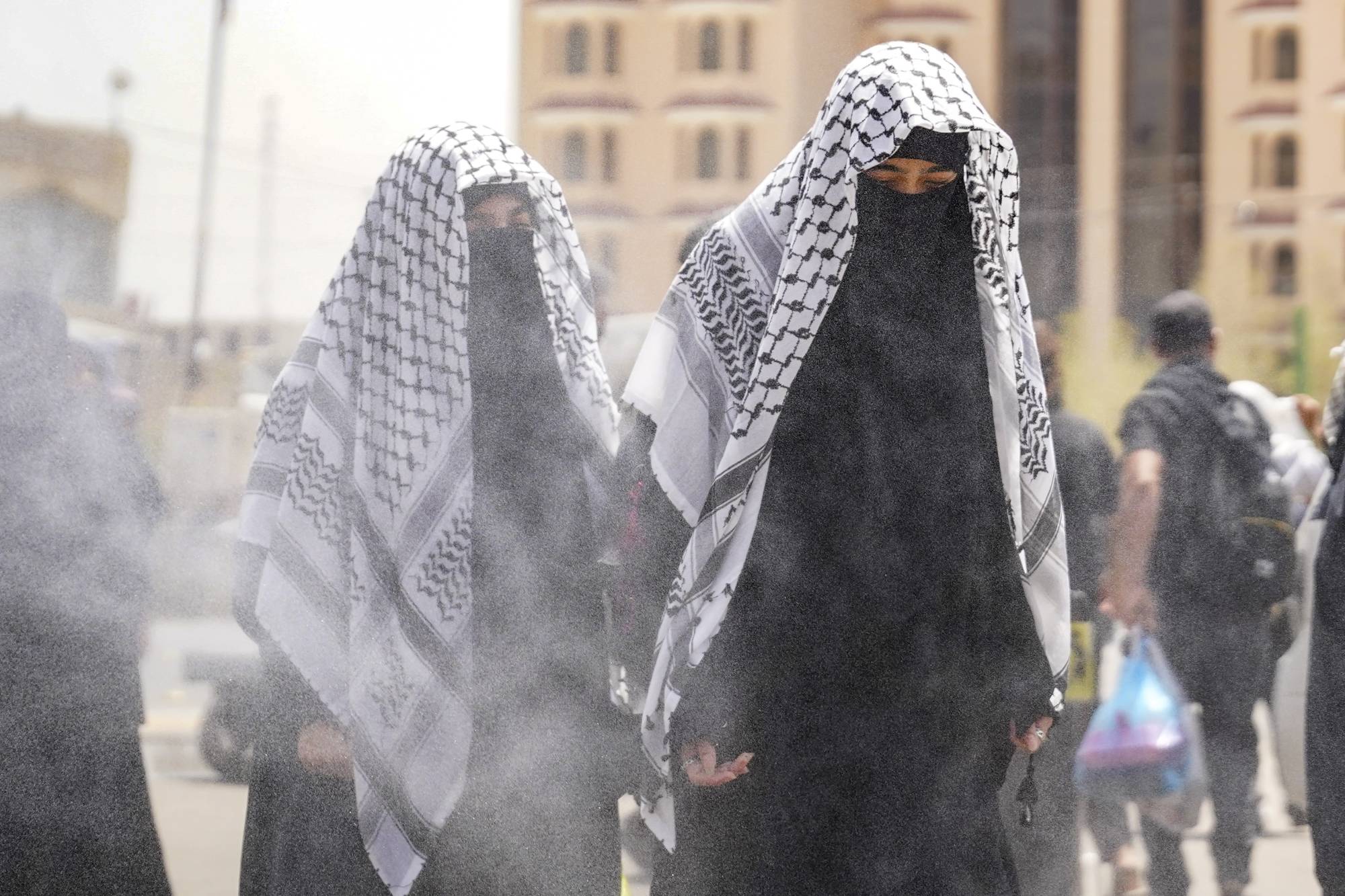 عراقيات يبردن أجسادهن بالماء بسبب الحرارة (أ.ب)