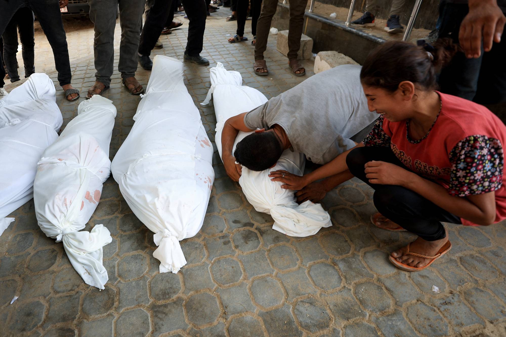 فتاة تبكي أبويها وشقيقها الذين قُتلوا في هجوم إسرائيلي على خيمة بمدينة غزة يوم الأربعاء (رويترز)