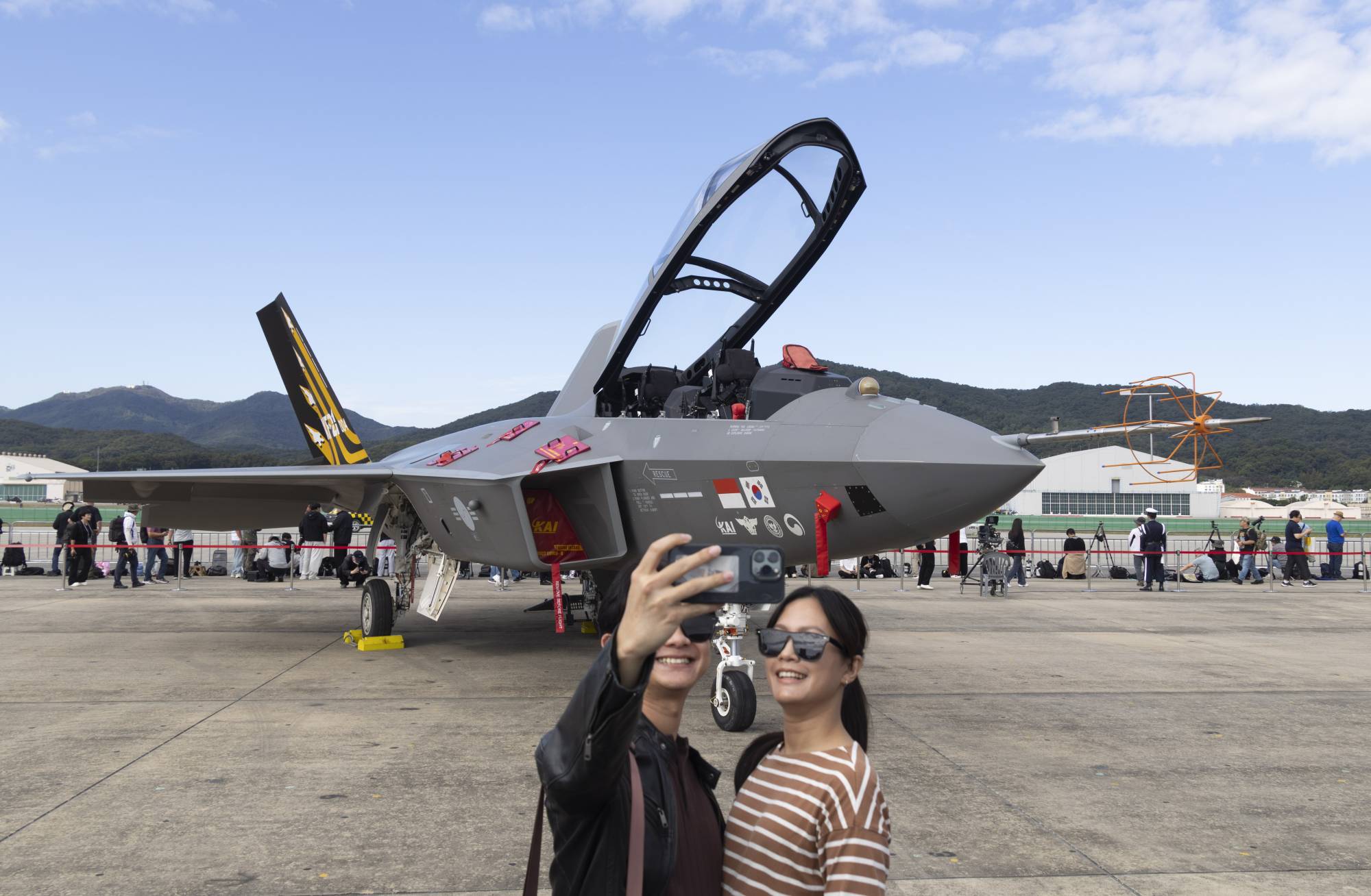 زوار يلتقطون صورة مع طائرة «KF-21» التابعة للقوات الجوية الكورية الجنوبية المعروضة خلال معرض سيول الدولي للفضاء والدفاع (ADEX) 2025 في مطار سيول العسكري في سيونغنام (إ.ب.أ)