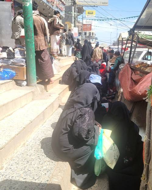 يمنيات يتجمعن لطلب المساعدة من أحد المتاجر في صنعاء (الشرق الأوسط)