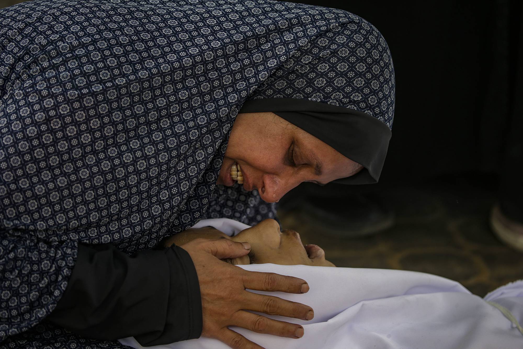 أم فلسطينية تنعى جثمان ابنها في مستشفى «الشفاء» بمدينة غزة (إ.ب.أ)