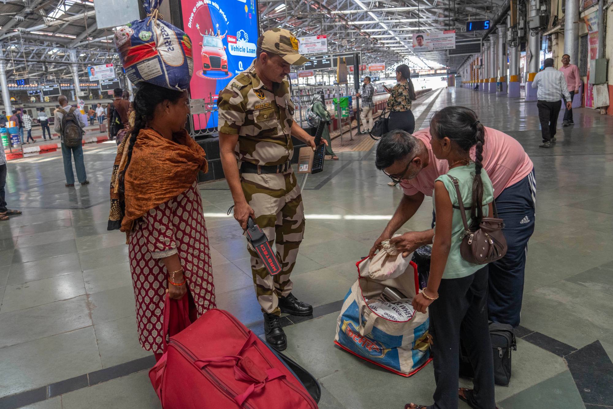 رجل أمن يفتش حقيبة أحد الركاب في محطة شاتراباتي شيفاجي في مومباي بالهند (أ.ب)