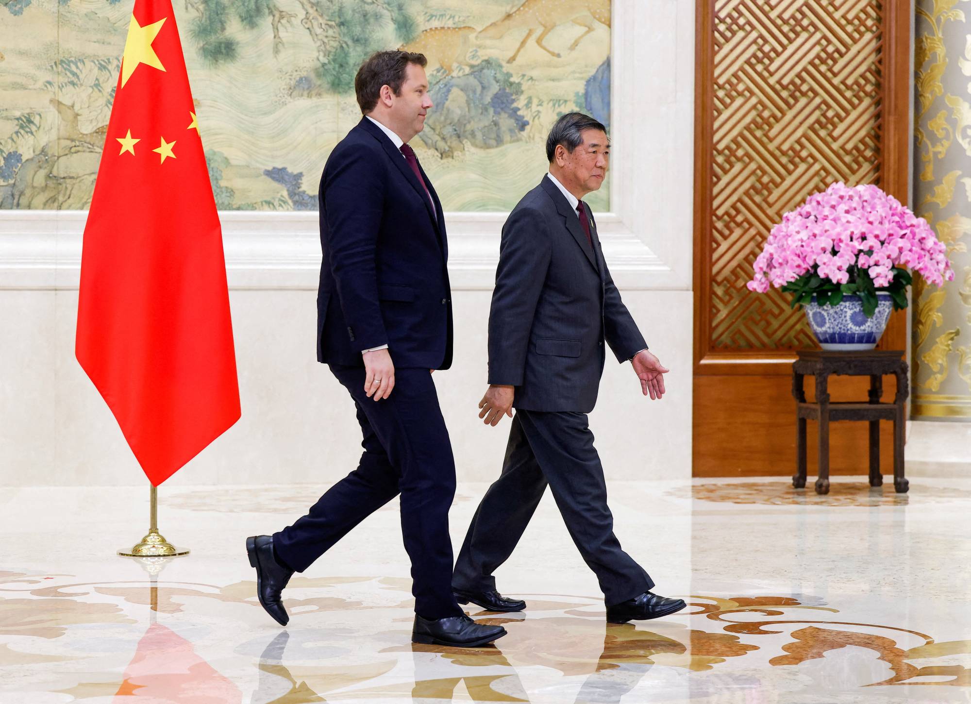 نائب المستشارة الألمانية ووزير المالية لارس كلينغبيل ونائب رئيس الوزراء الصيني هي ليفينغ يغادران اجتماعاً في بكين (رويترز)