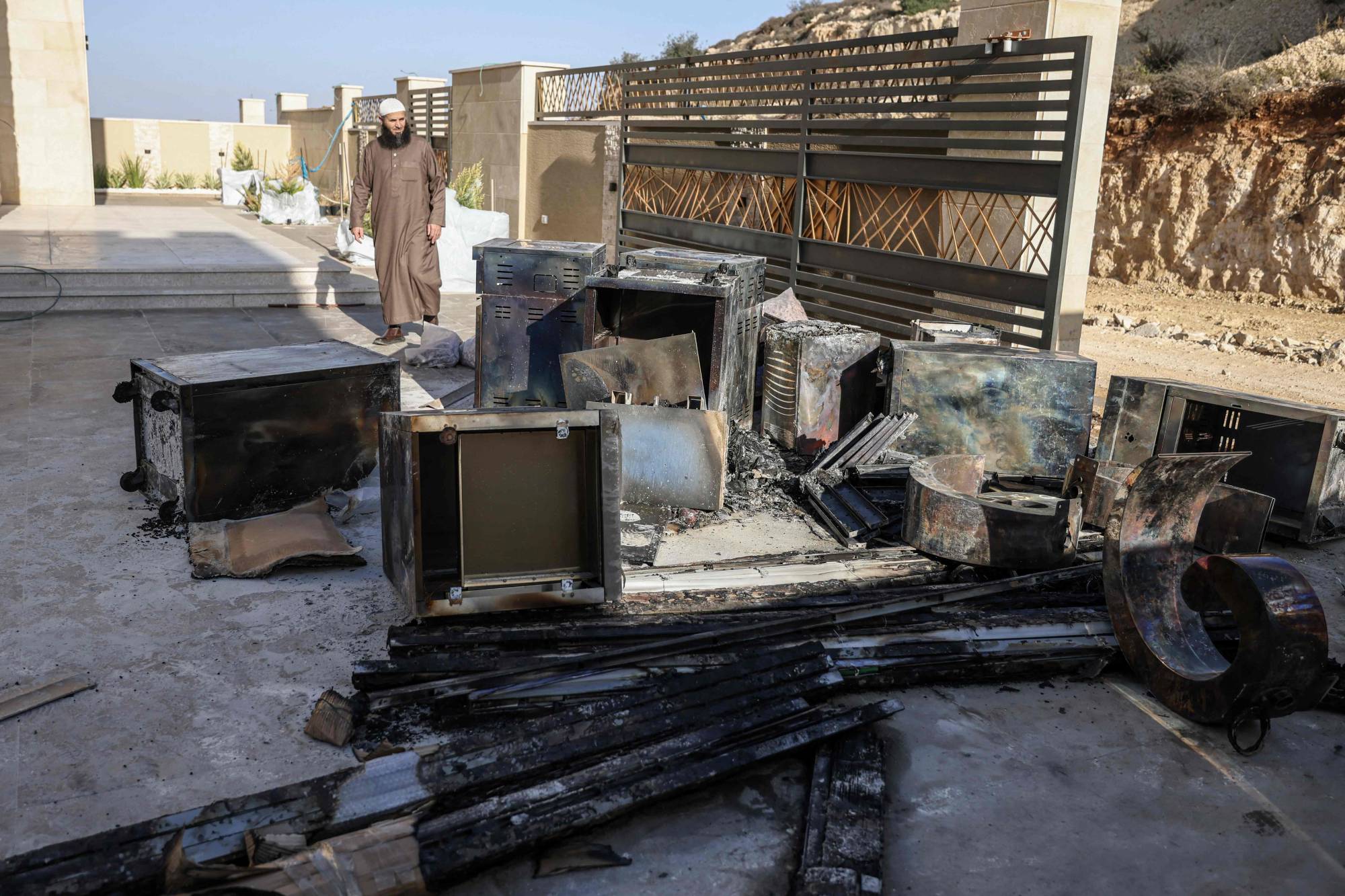 فلسطيني يعاين أضراراً أوقعها مستوطنون ببيت سياحي قيد البناء قرب نابلس الجمعة (أ.ف.ب)