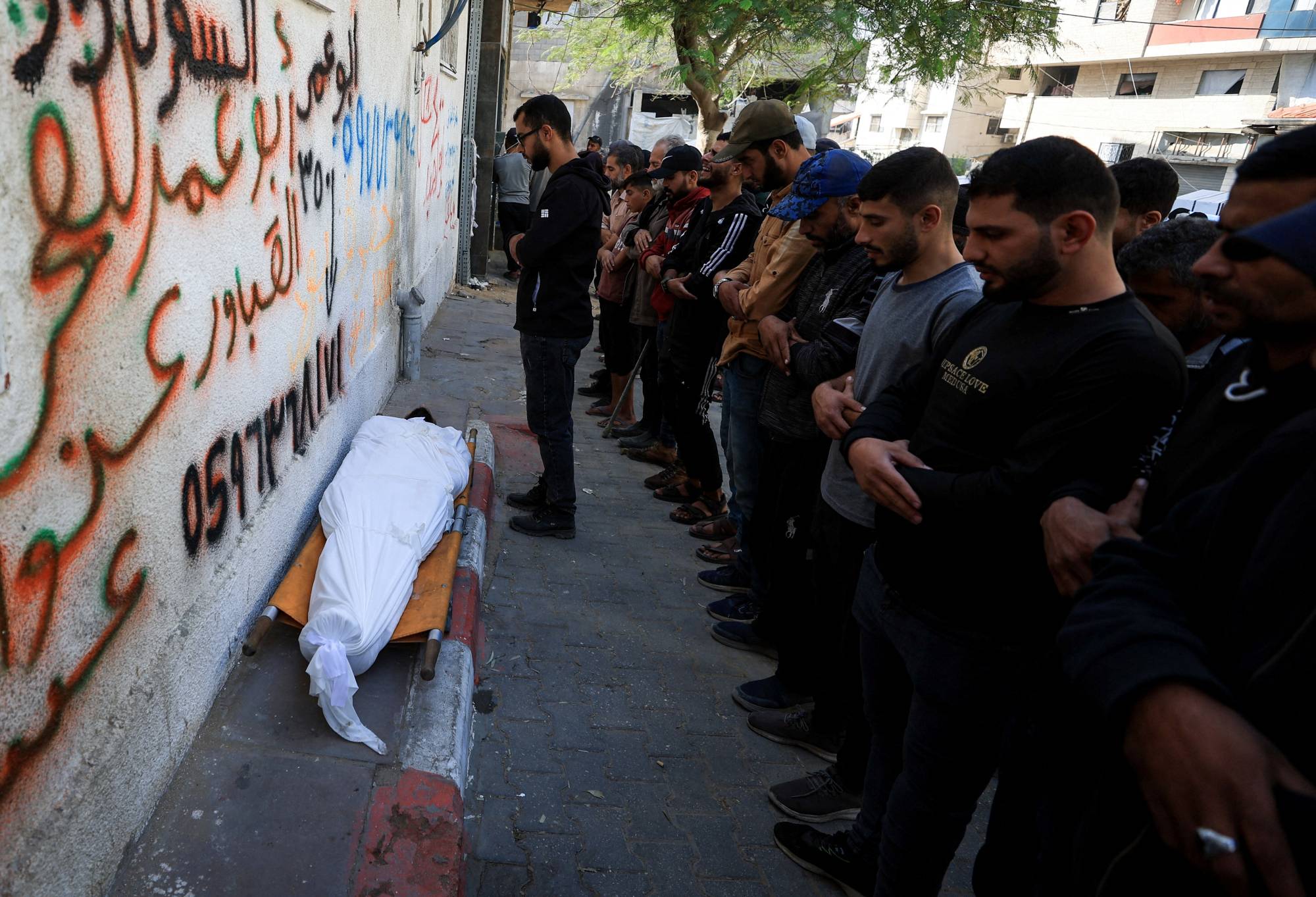 مشيعون يشاركون في جنازة الشاب الفلسطيني أحمد الهواري الذي قُتل بنيران إسرائيلية في مدينة غزة (رويترز)