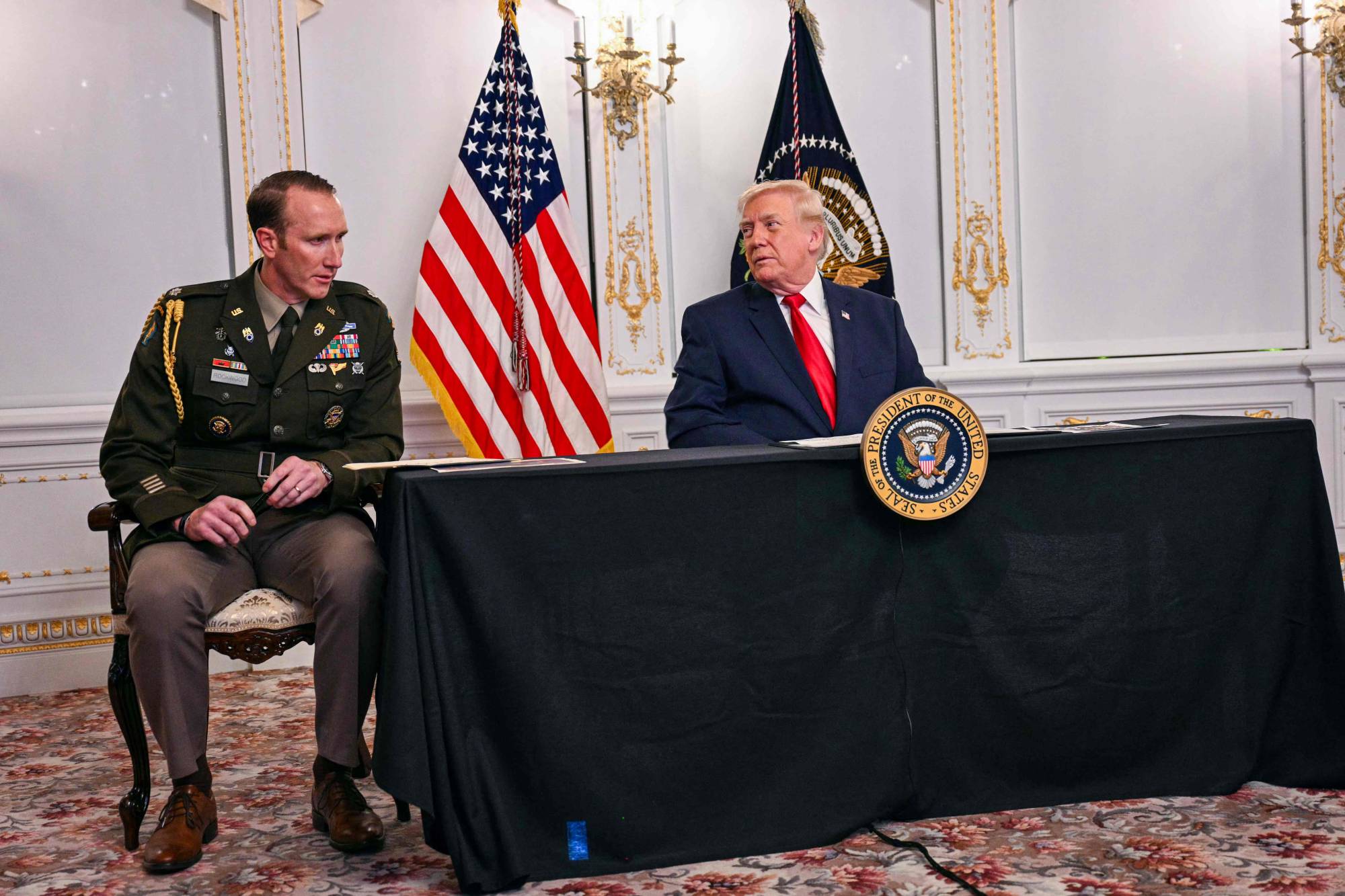 ترمب متحدثاً عبر دائرة الفيديو مع أفراد من الجيش الأميركي من منتجعه في فلوريدا (ا.ف.ب)