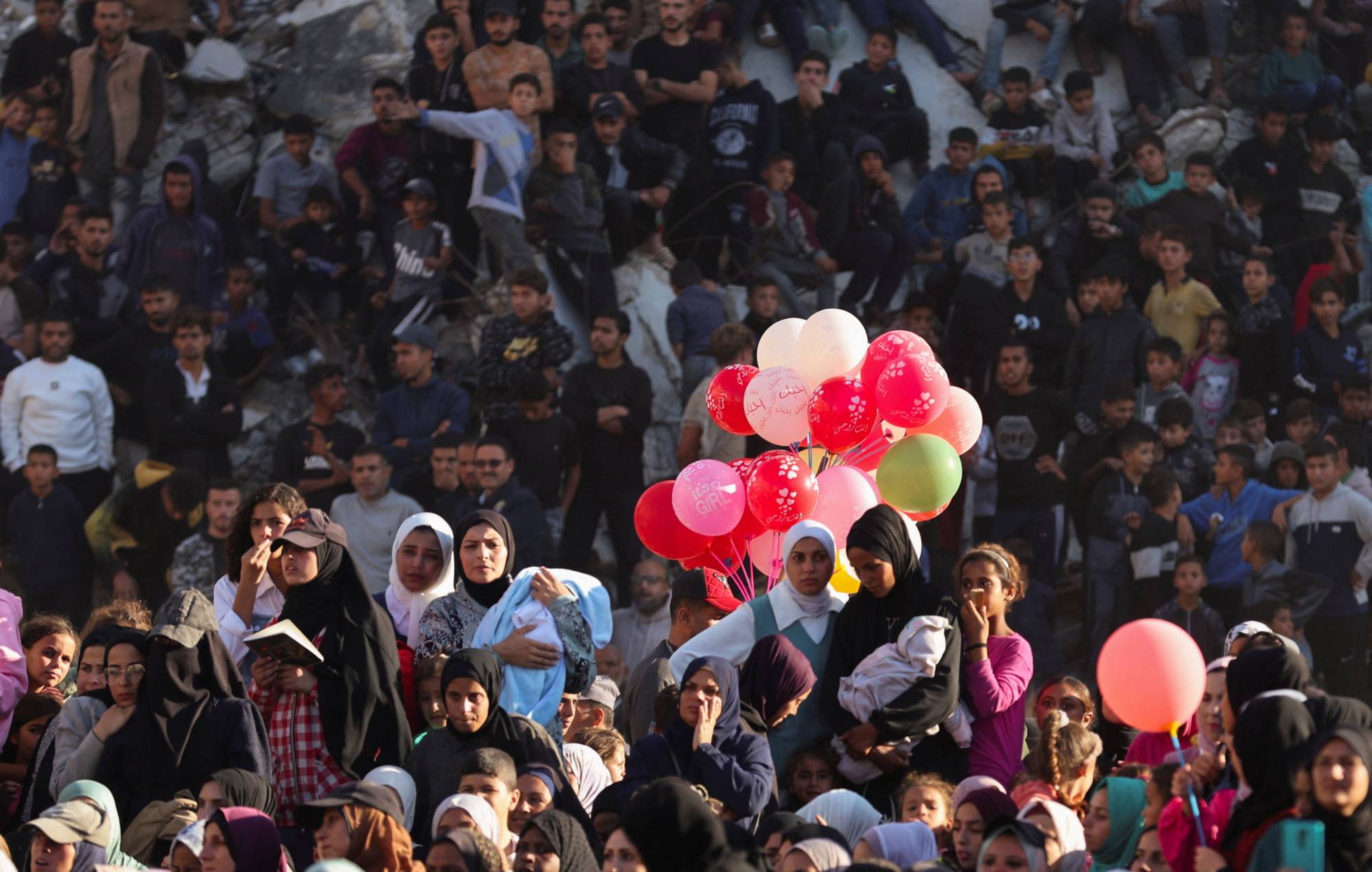 فلسطينيون يشاهدون حفل زفاف جماعي لـ54 زوجاً في خان يونس جنوب قطاع غزة (رويترز)