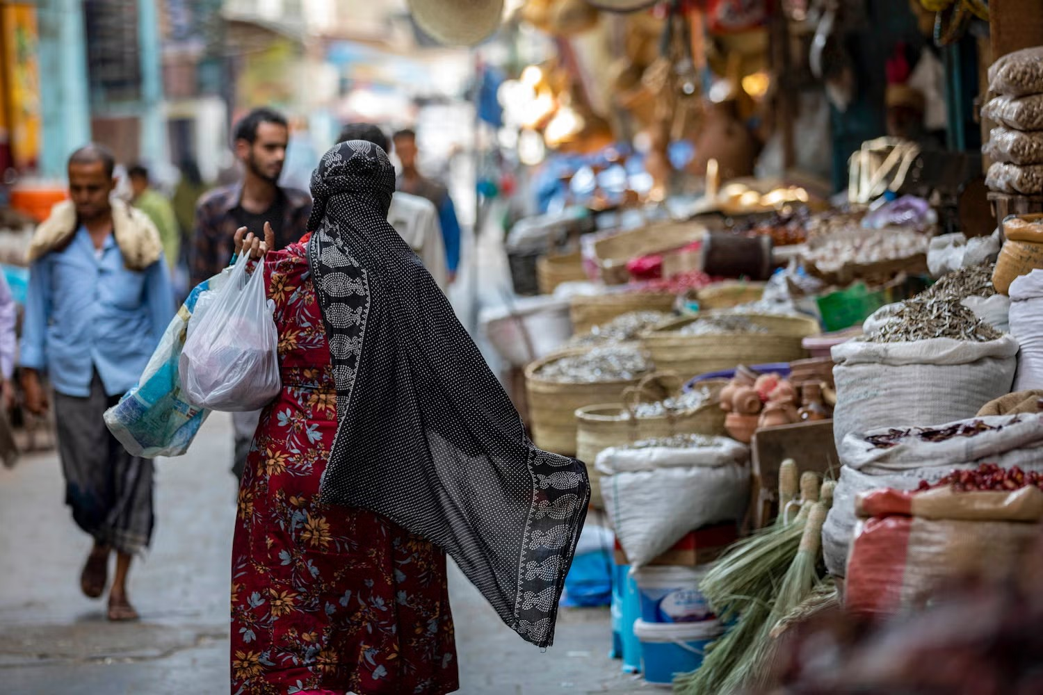 امرأة تتجول في أحد أسواق مدينة تعز حيث الغلاء يخنق القدرة الشرائية للسكان (أ.ف.ب)