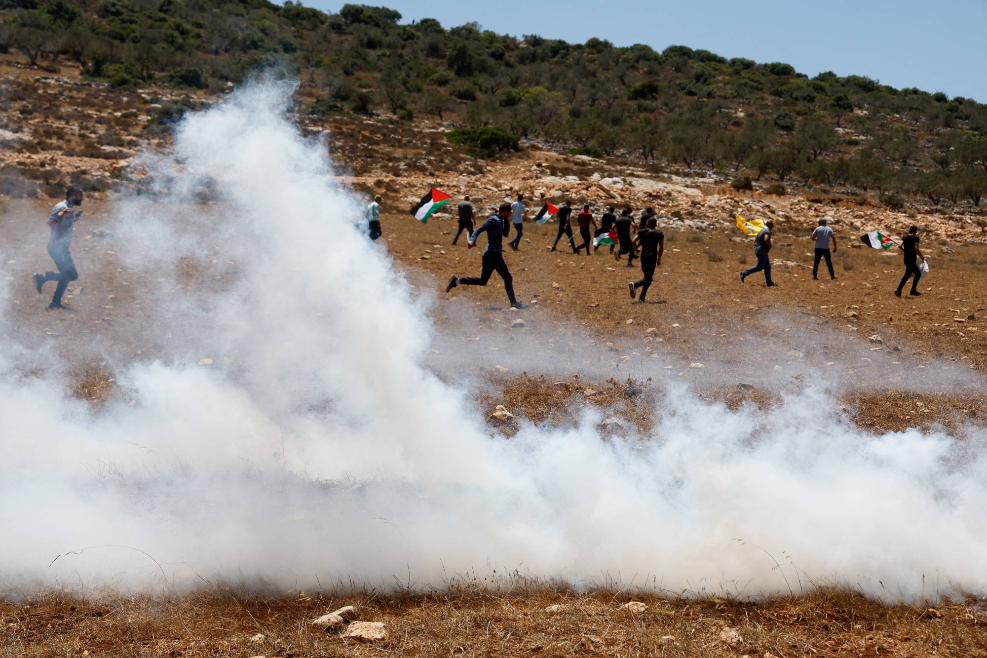 Filistinliler cuma günü Cenin yakınlarındaki Raba köyünde topraklarına el konulmasına karşı düzenledikleri gösteride göz yaşartıcı gaza maruz kaldılar. (Reuters)