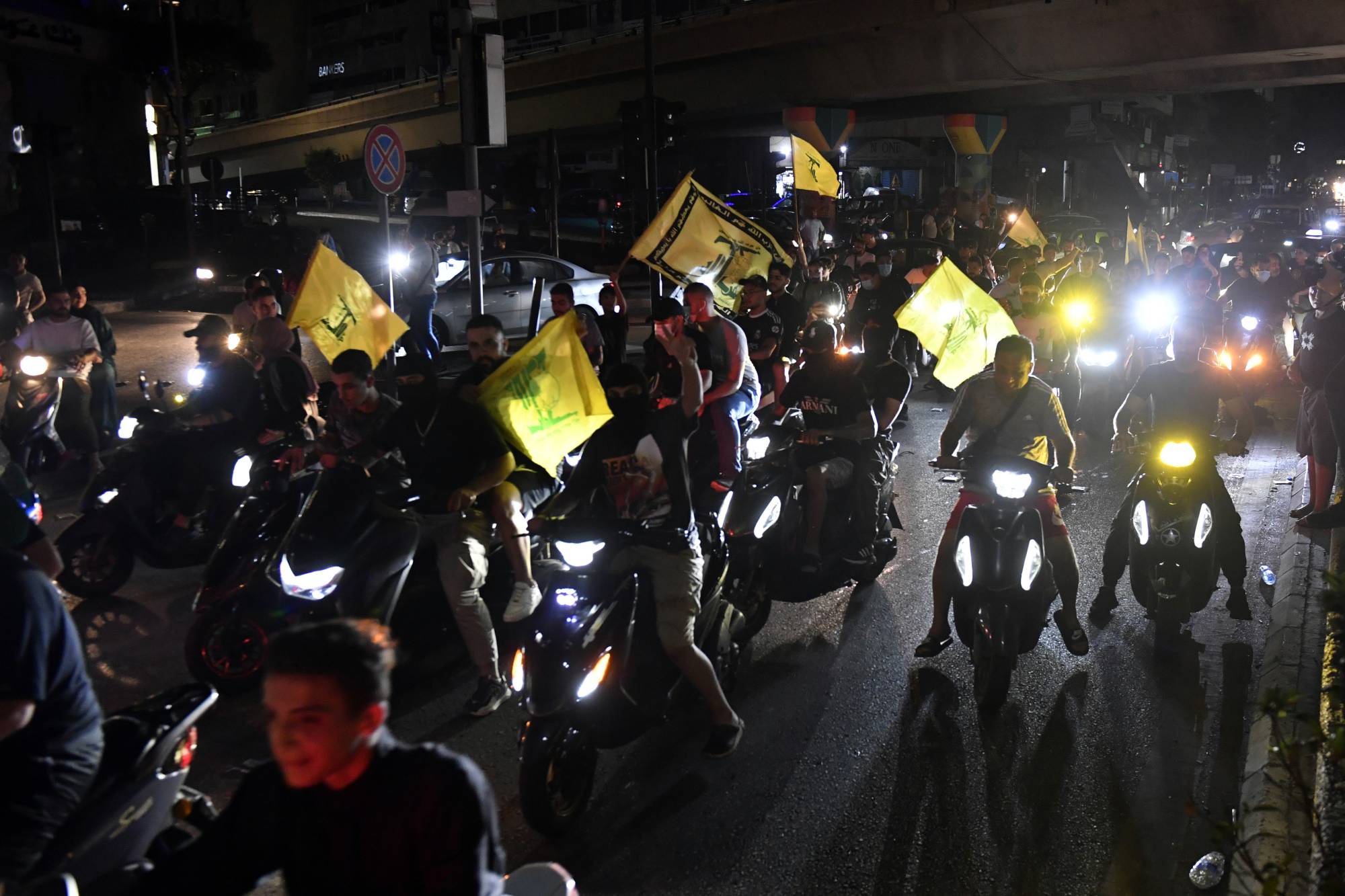 Lübnan hükümetinin Hizbullah’ı silahsızlandırma planını onaylamasını protesto etmek için Beyrut'un güney banliyölerinde motosikletlerle düzenlenen gösteride bayrak sallayan Hizbullah destekçileri (EPA)