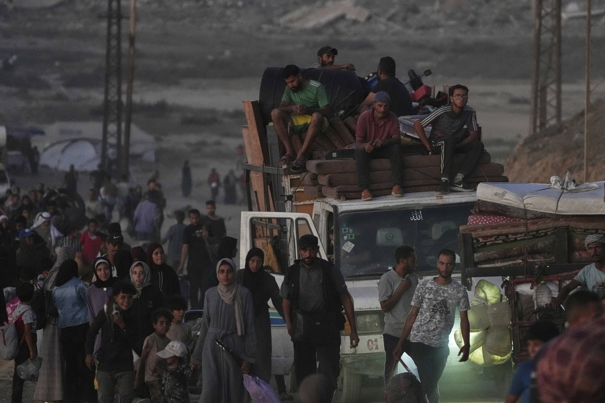 Yerinden edilmiş Filistinliler, eşyalarını Nuseyrat'taki sahil yolundan güney Gazze Şeridi'ne doğru yaya ve araçlarla taşıyarak Gazze Şehri'nden kaçıyor (AP)