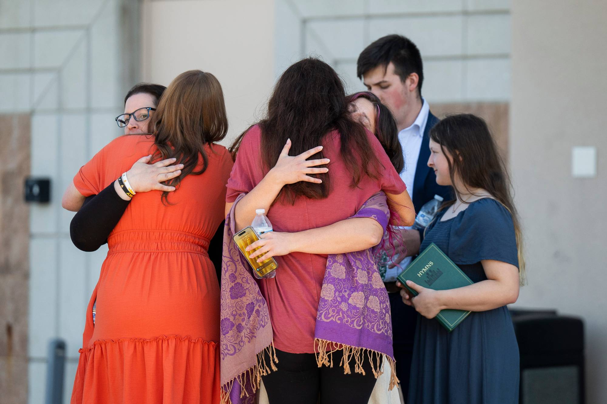  Michigan'daki bir Mormon kilisesine düzenlenen saldırıdan kurtulanlar, saldırının gerçekleştiği yerin yakınında akrabaları ve arkadaşlarıyla buluşuyor. (AP)
