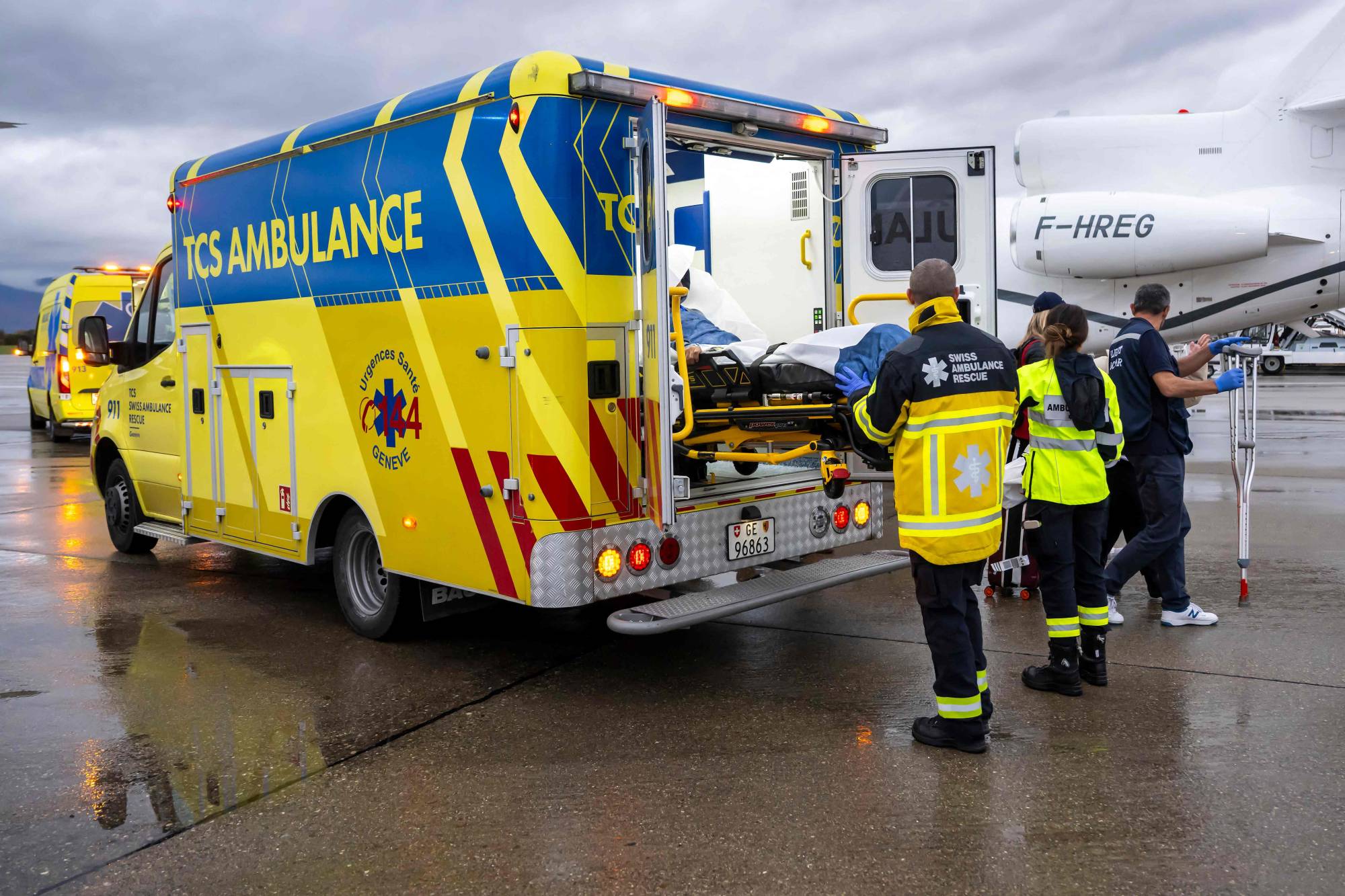 İsviçre'nin Zürih Havalimanı'nda hasta çocukları uçaktan ambulansa aktaran bir sağlık ekibi (AFP)