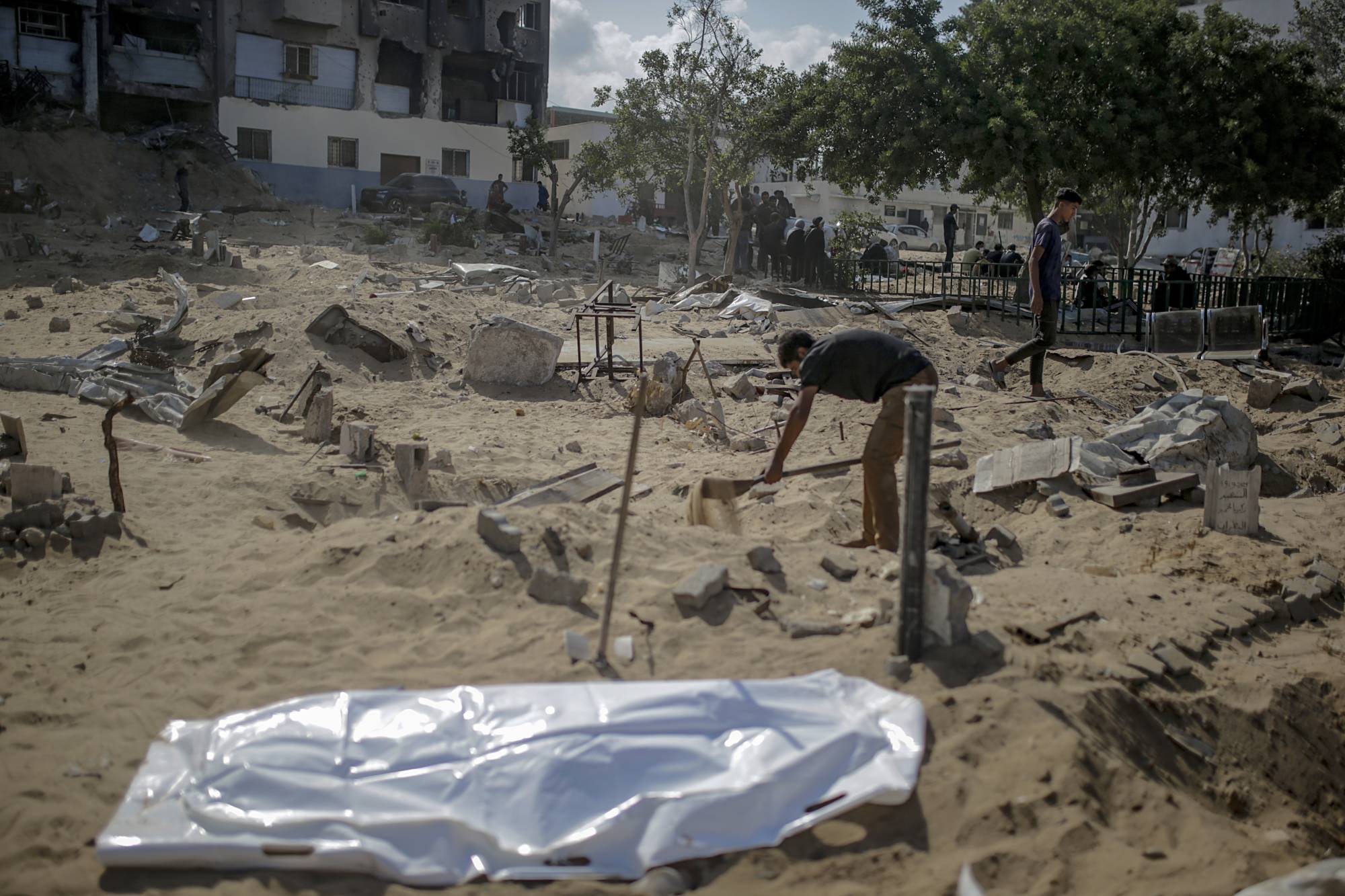 Gazze şehrindeki Şifa Hastanesi'nin arazisinden savaş sırasında öldürülen aile üyelerinin cenazelerini çıkaran Filistinliler (EPA)