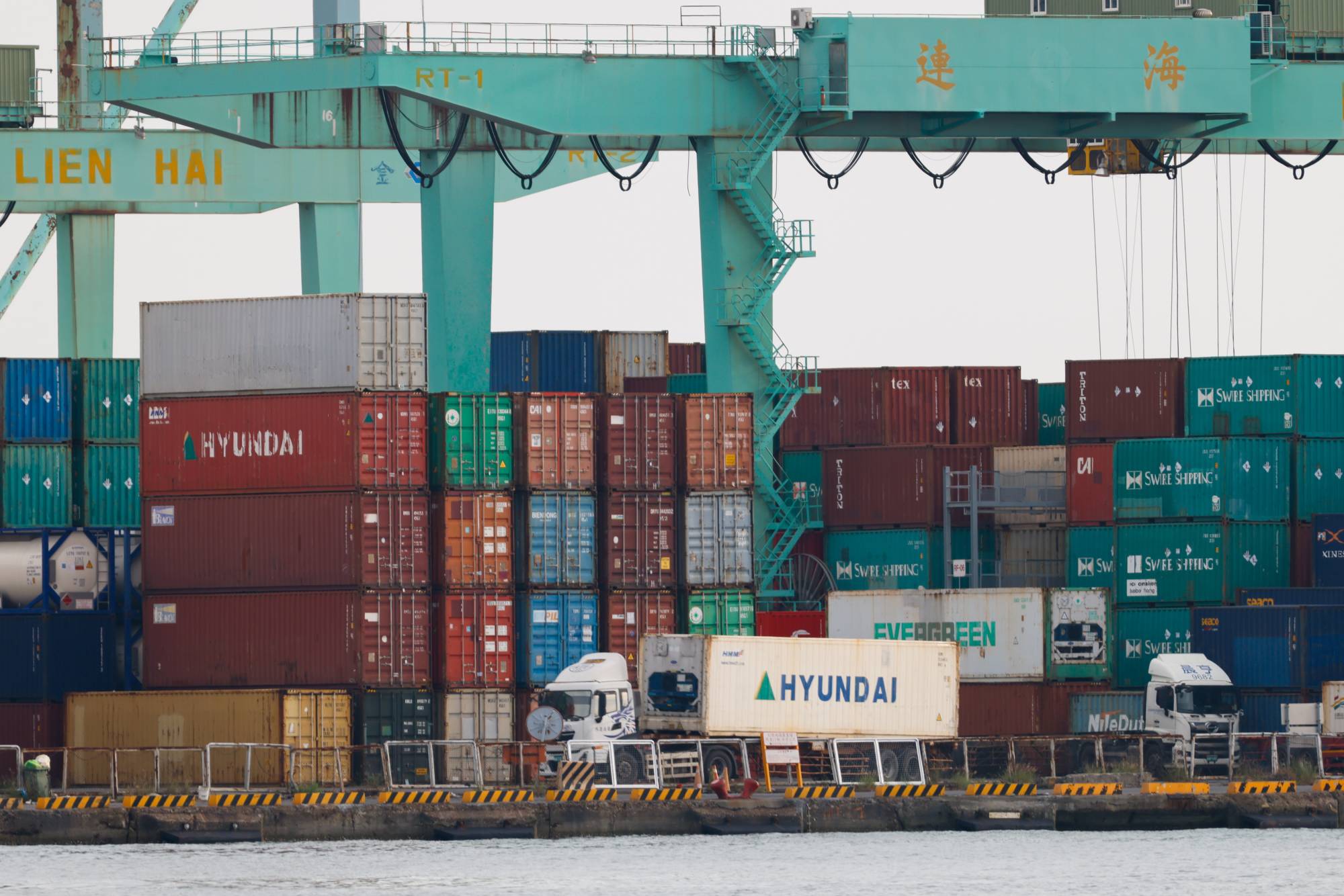 Tayvan'ın Kaohsiung Limanı’nda tırlar konteynerleri taşıyor. (EPA)