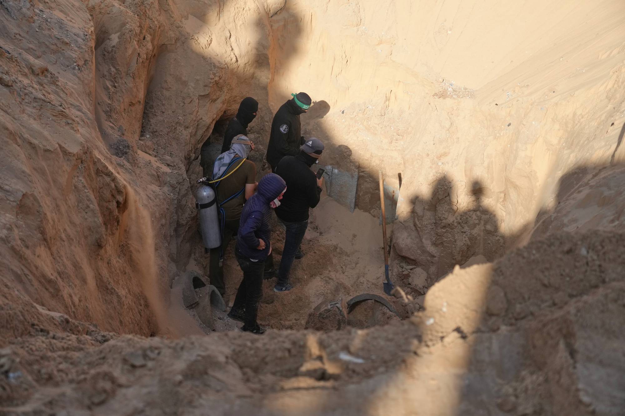 Hamas'ın askeri kanadı Kassam Tugayları, Gazze Şeridi'nin güneyinde arama çalışmaları sırasında keşfedilen bir tünelde rehinelerin cesetlerini arıyor (AP)