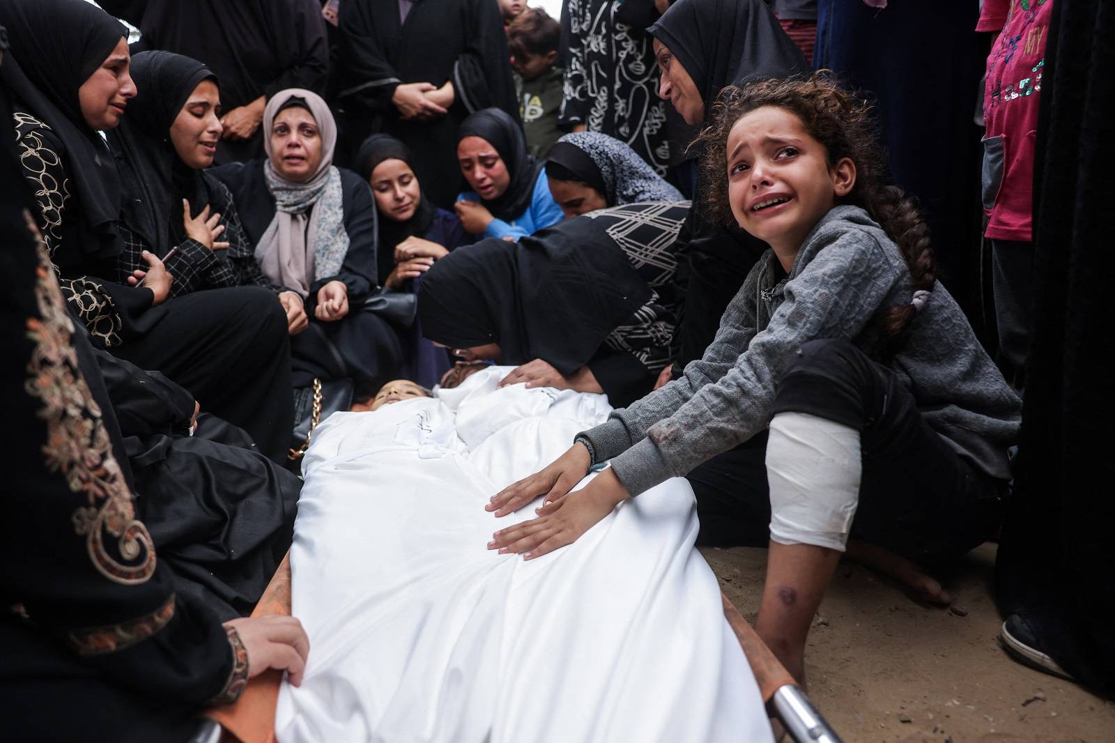 Han Yunus'taki Nasır Hastanesi'ne düzenlenen İsrail hava saldırısında hayatını kaybeden iki çocuğun cenazesi başında göz yaşı döken Filistinliler (AFP)