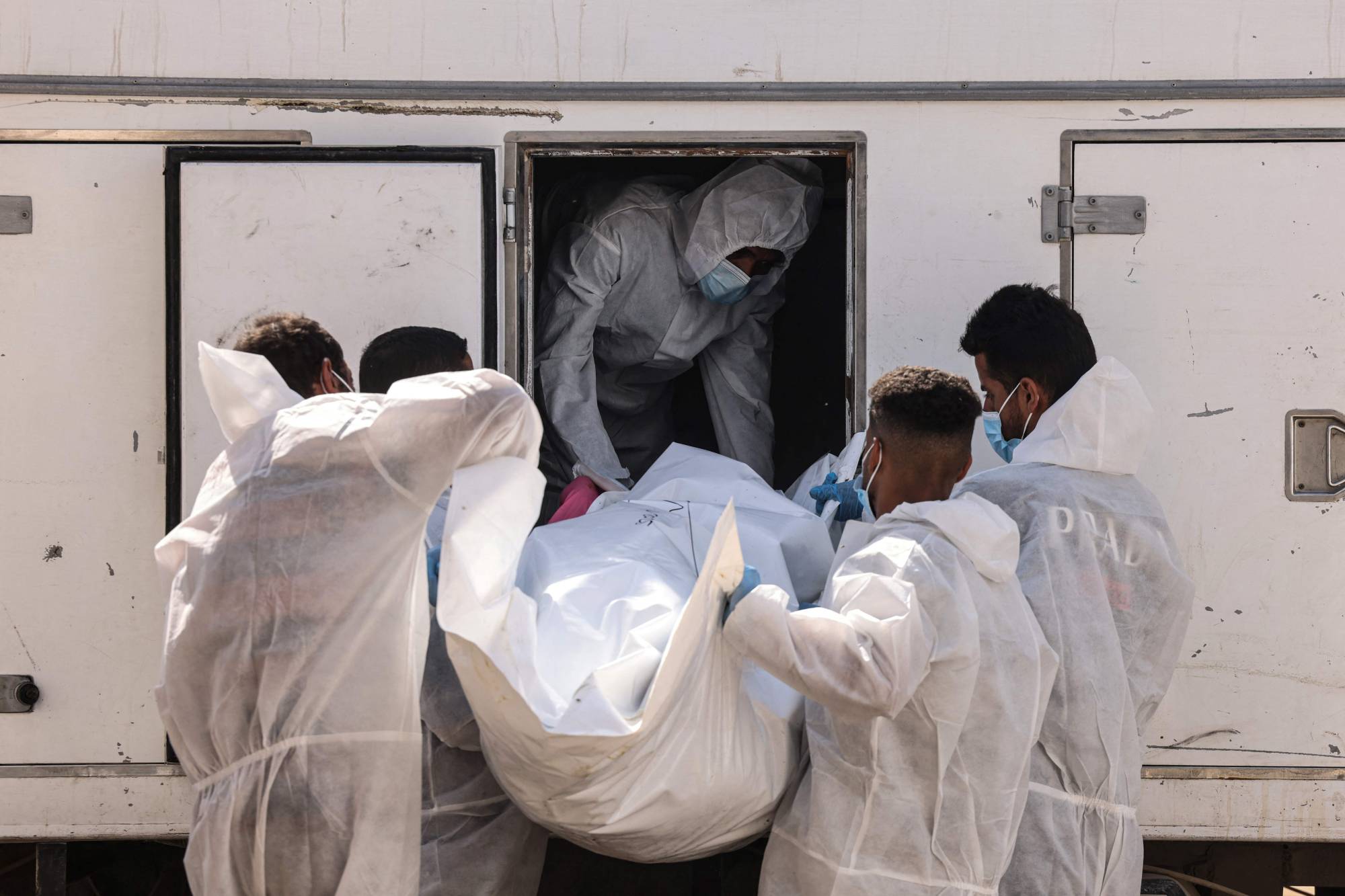 İsrail'in elinde bulunan ve esir değişim anlaşması kapsamında serbest bırakılan 30 Filistinli tutsağın ceset torbaları Han Yunus'a ulaşırken, Nasır Tıp Merkezi personeli ceset torbalarını çıkarıyor (AFP).