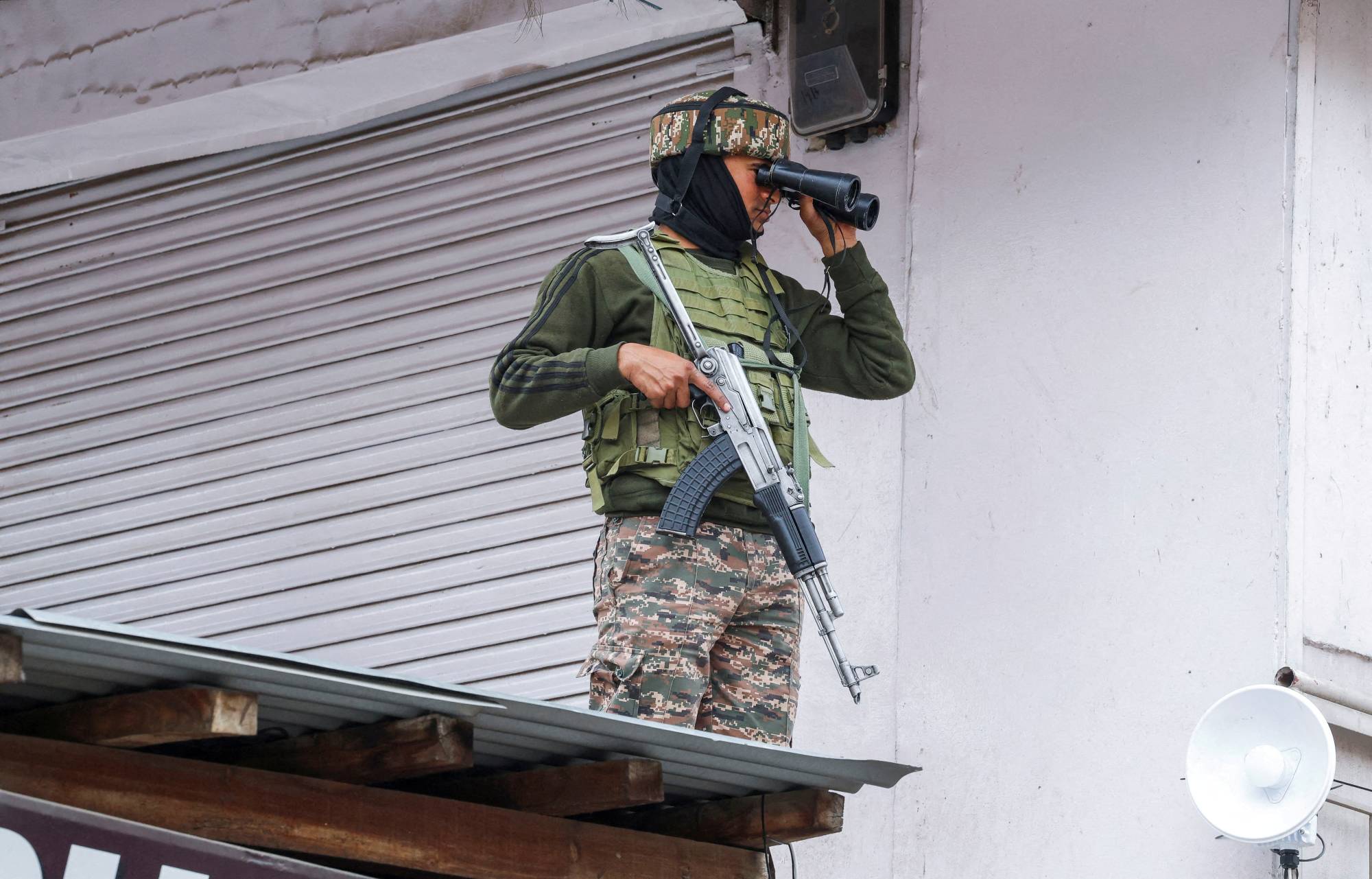 Bir Hint güvenlik mensubu dürbünle gözetleme yapıyor (Reuters)