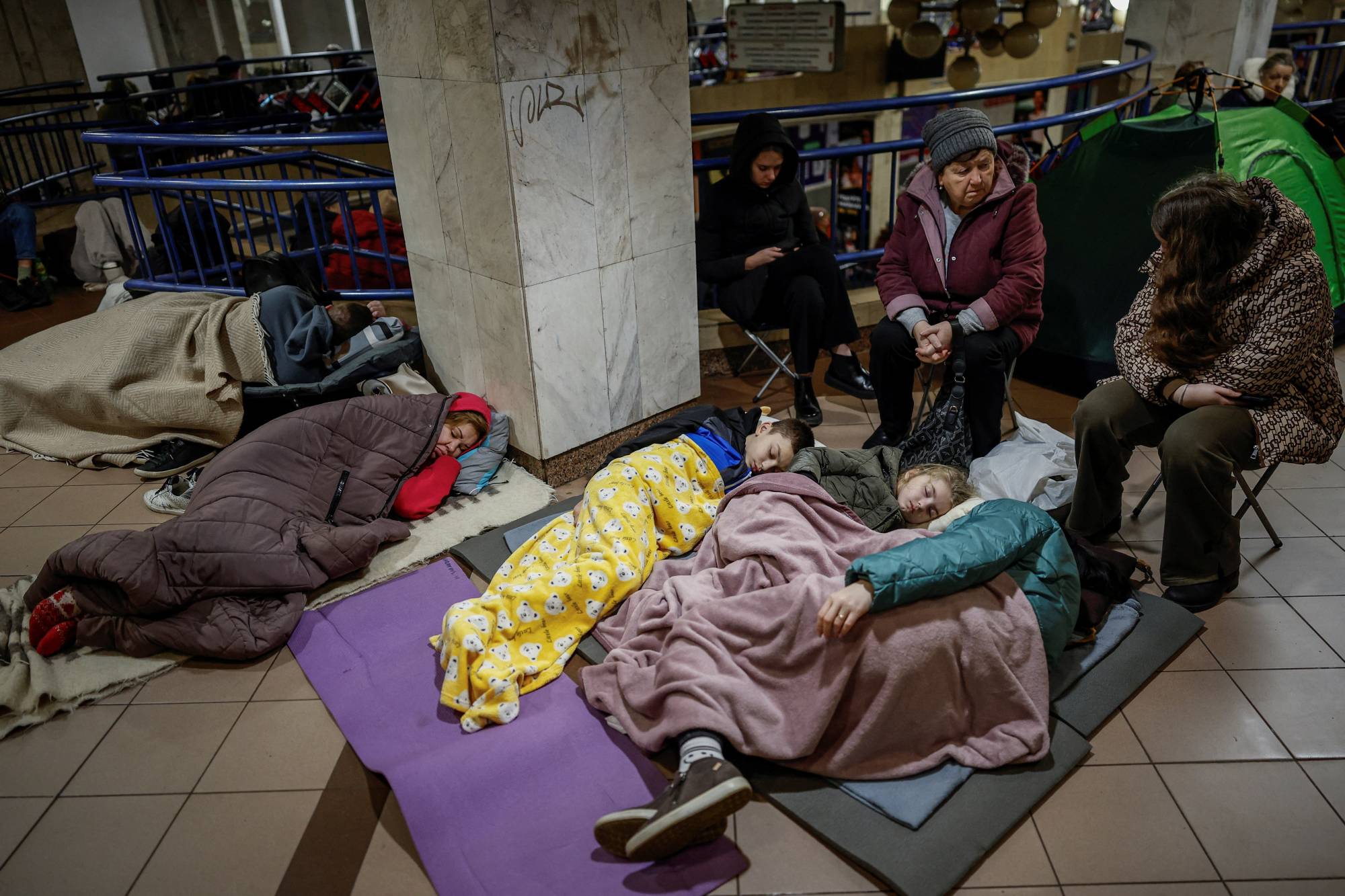 Rusların bugün Ukrayna'nın başkenti Kiev'i hedef alan saldırısı sırasında insanlar bir metro istasyonuna sığındı (Reuters)