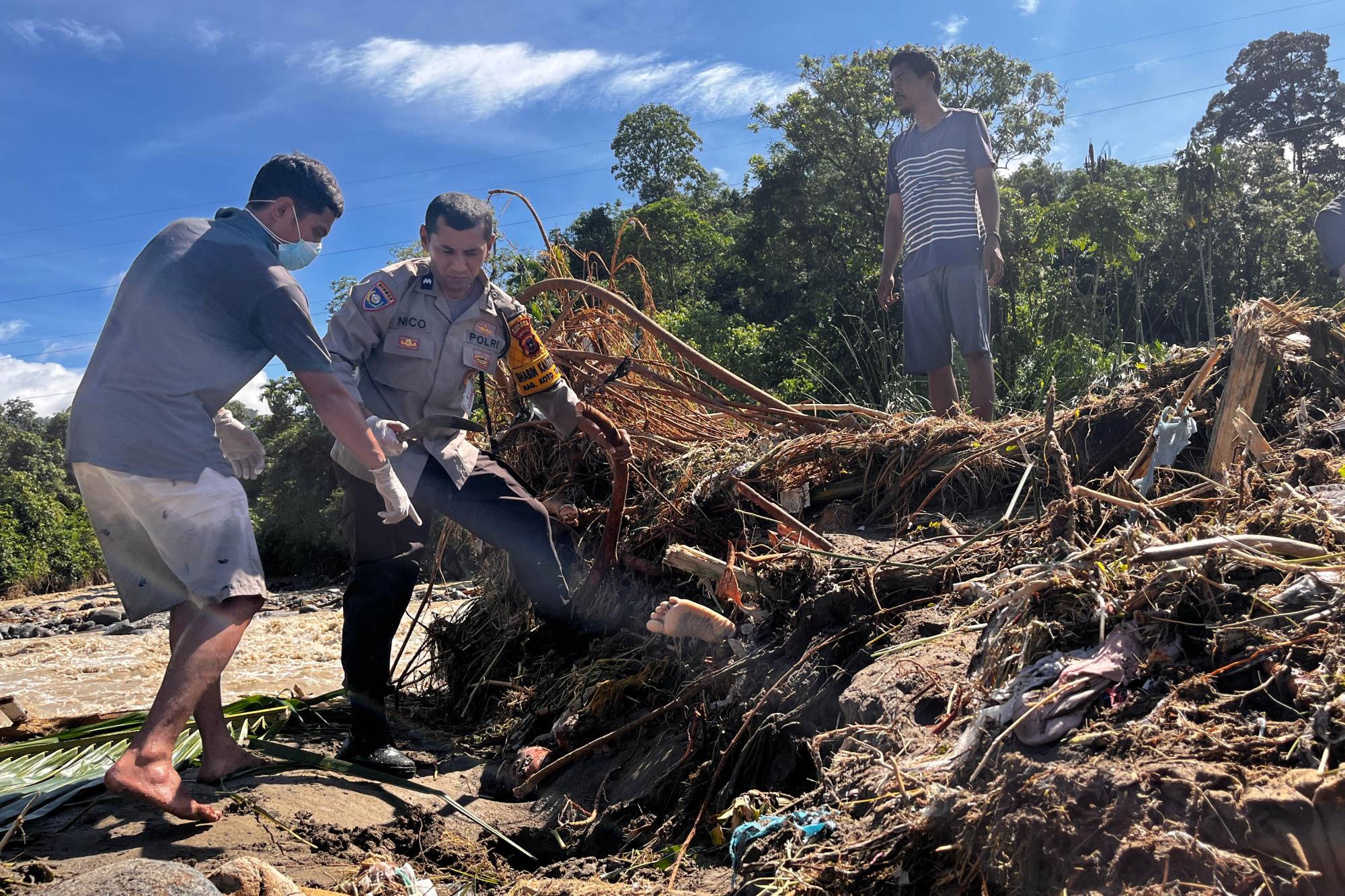 Batı Sumatra'nın Padang Pariaman kentinde kurtarma ekipleri, sel mağdurunun cesedini çamur ve enkaz altından çıkarmaya çalışıyor (AP)