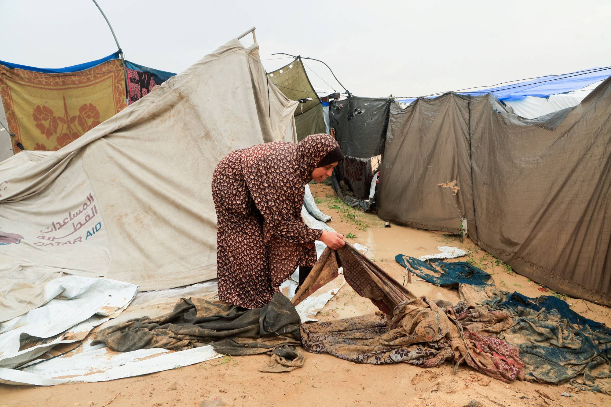  Gazze Şeridi'nin güneyinde Han Yunus'taki bir kampta yağmurlu bir günde yerinden edilmiş Filistinli kadın (Reuters)
