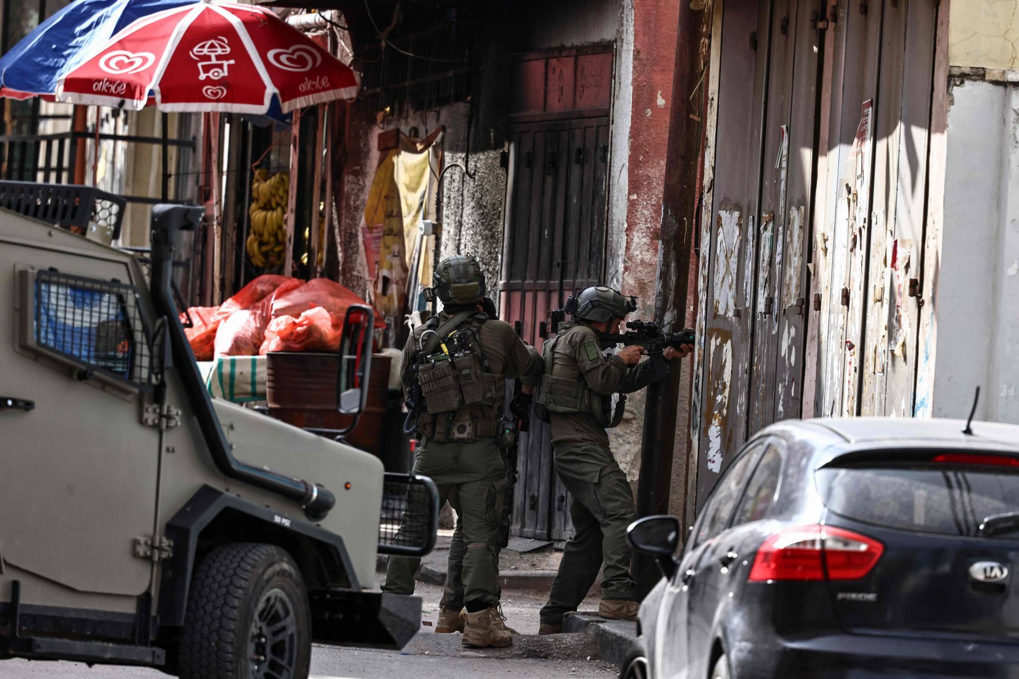  İsrail askerleri, Batı Şeria'daki Ramallah yakınlarındaki el-Amari mülteci kampına düzenlenen askeri baskın sırasında mevzi alıyor (AFP)
