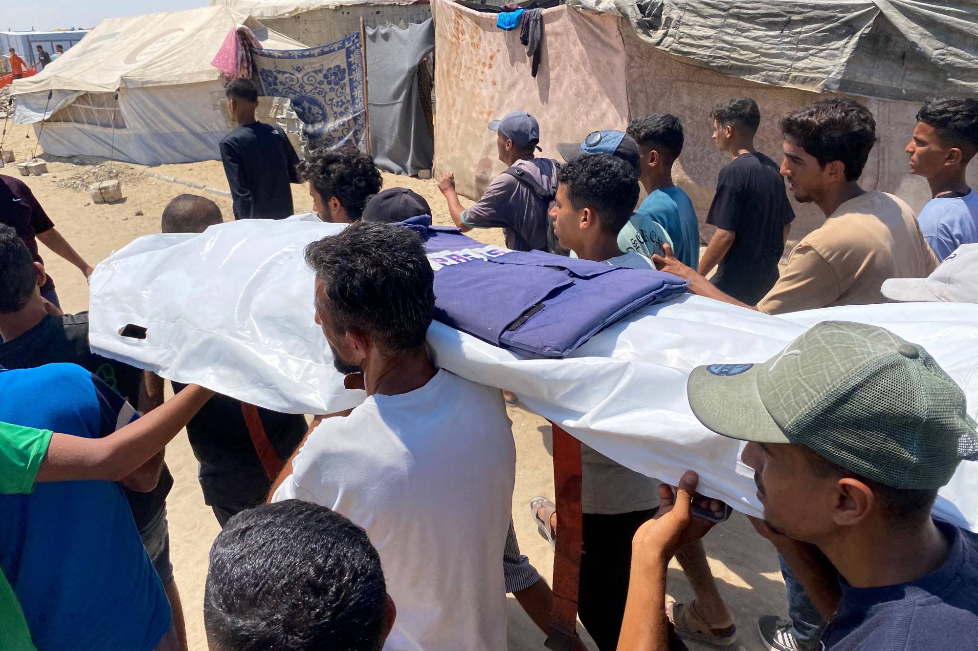 Geçtiğimiz ağustos ayında Gazze Şeridi'nin güneyindeki Han Yunus'ta bulunan Nasır Hastanesi'ne düzenlenen İsrail baskınında öldürülen beş gazeteciden birinin naaşını taşıyanlar... (AFP)