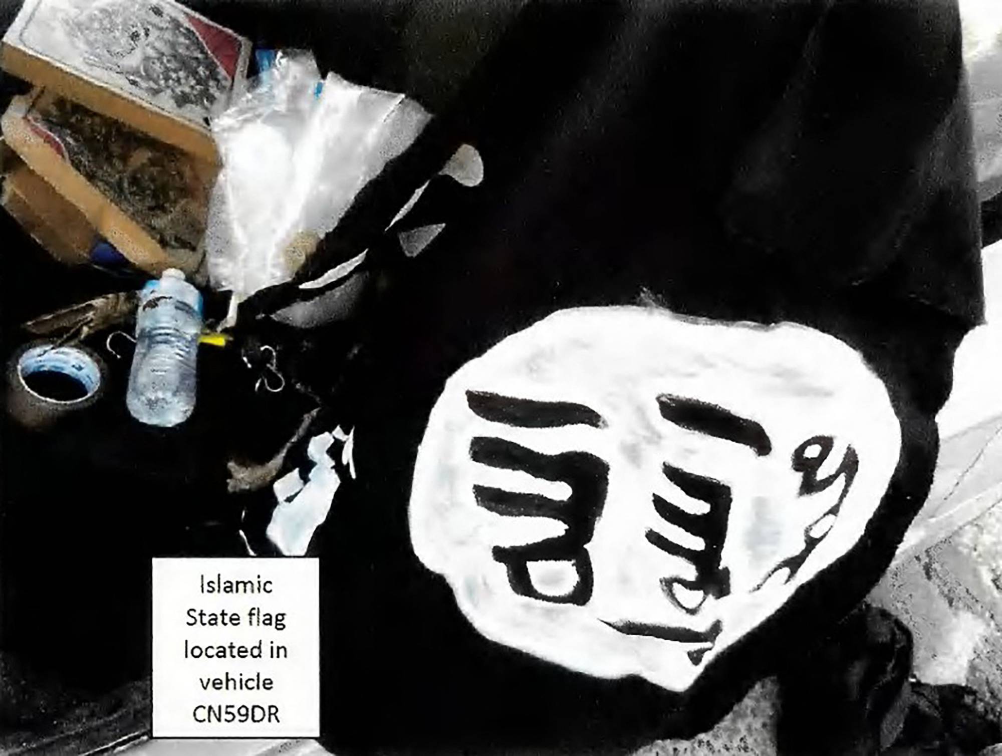 Yeni Güney Galler Mahkemeleri tarafından 22 Aralık 2025 tarihli Polis Bilgi Formu'nda yayınlanan bir mahkeme deliline eklenen bu fotoğraf, Sydney'de Naveed Akram adına kayıtlı CN59DR plakalı aracın içinde bulunan ve siyah kumaş üzerine beyaz boyayla yapılmış gibi görünen ev yapımı bir DEAŞ bayrağını göstermektedir (AFP)
