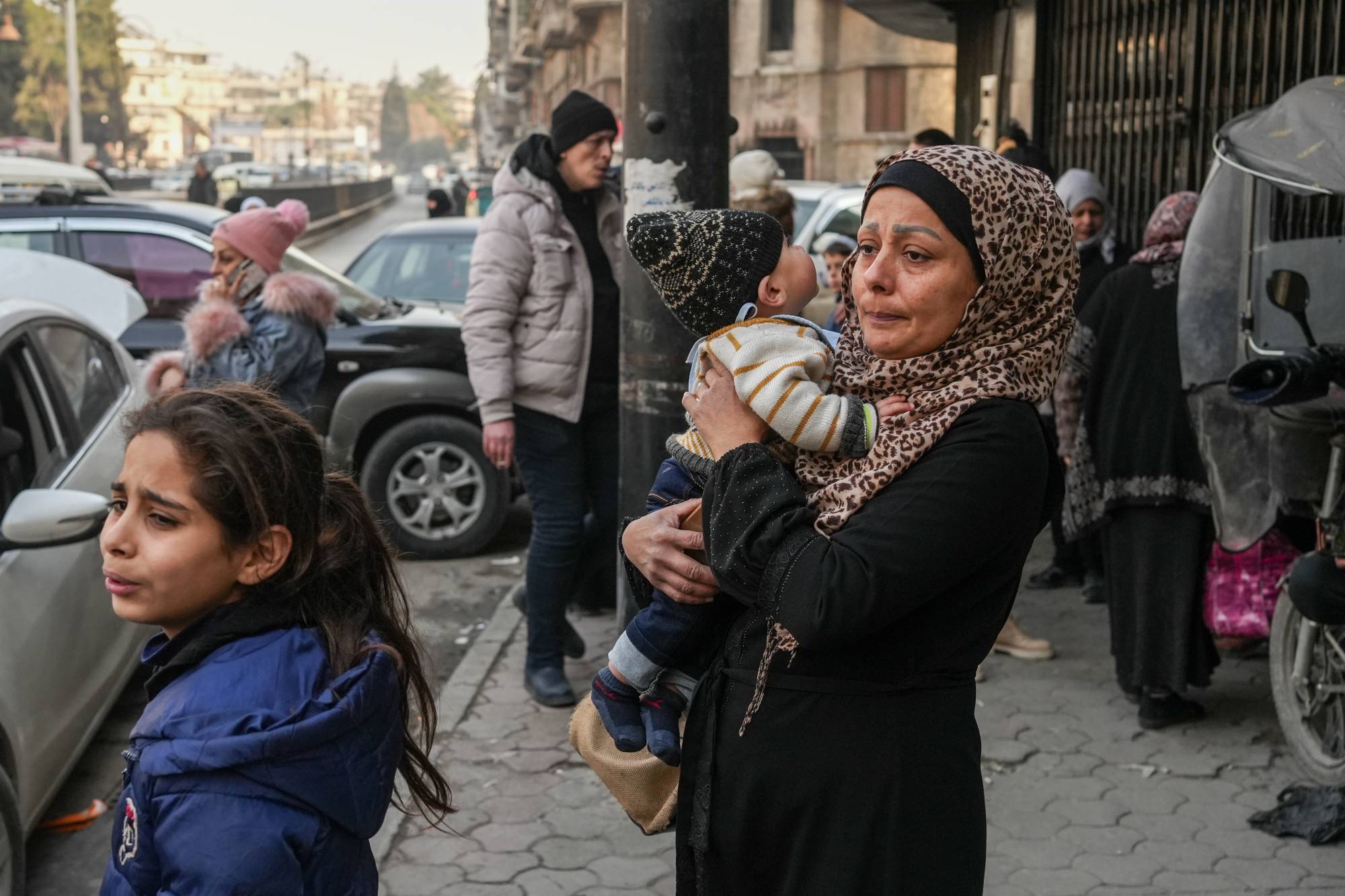  7 Ocak 2026'da Suriye'nin Halep kentinden kucağındaki çocuğuyla kaçan bir anne (EPA)