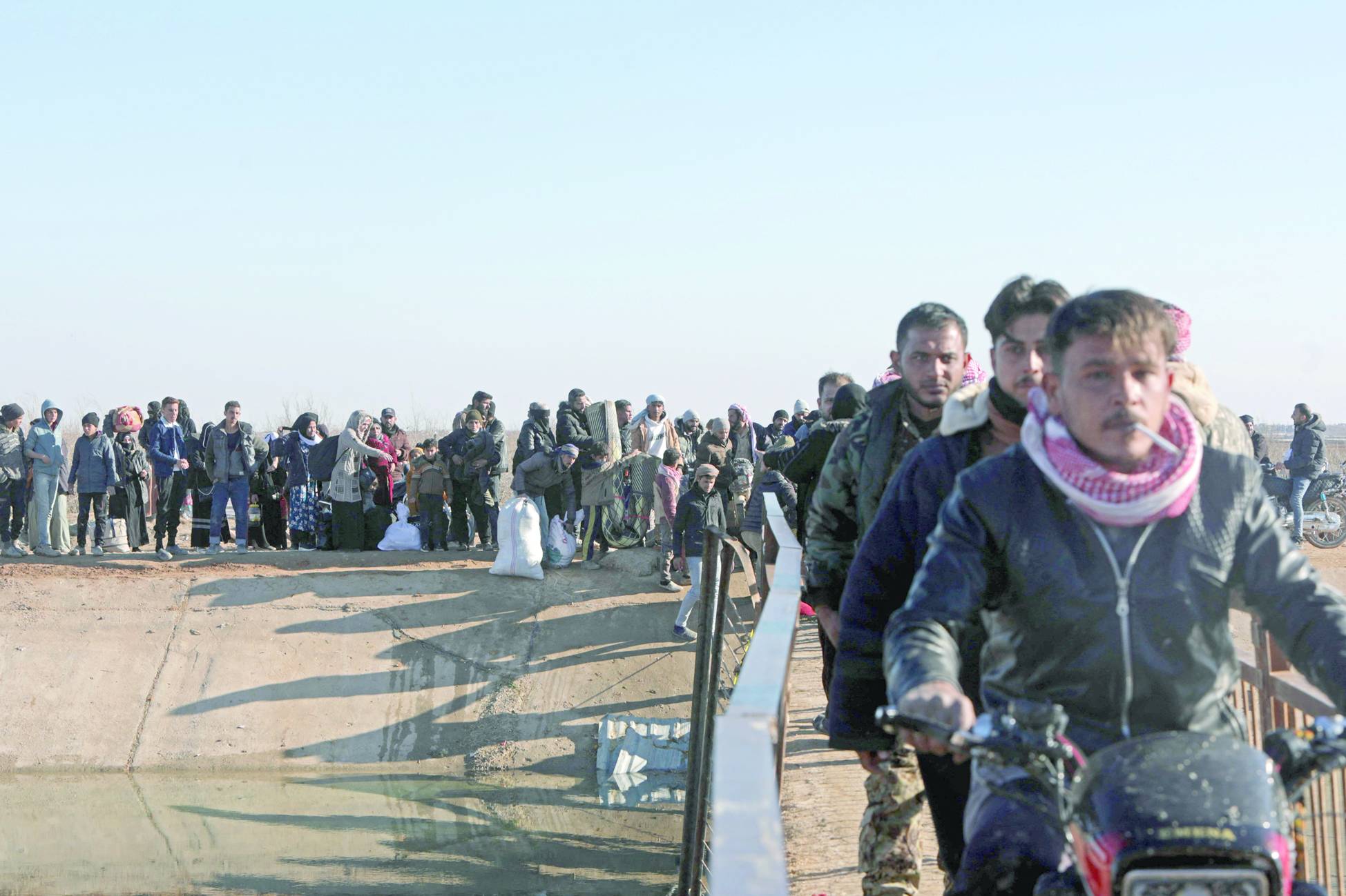 Halep'in doğusunda SDG ile Suriye ordusu arasındaki çatışma bölgelerinden kaçan siviller (AFP)