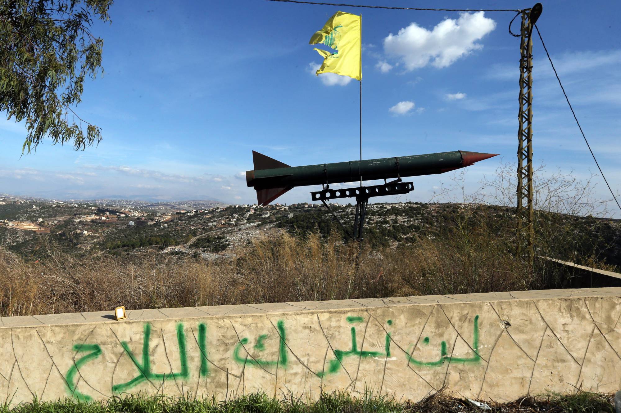  Hizbullah tarafından Lübnan'ın güneyindeki Kaleviyeh köyüne yerleştirilen bir füze maketi… Duvarda “Silahlarımızı bırakmayacağız” yazıyor. (EPA)