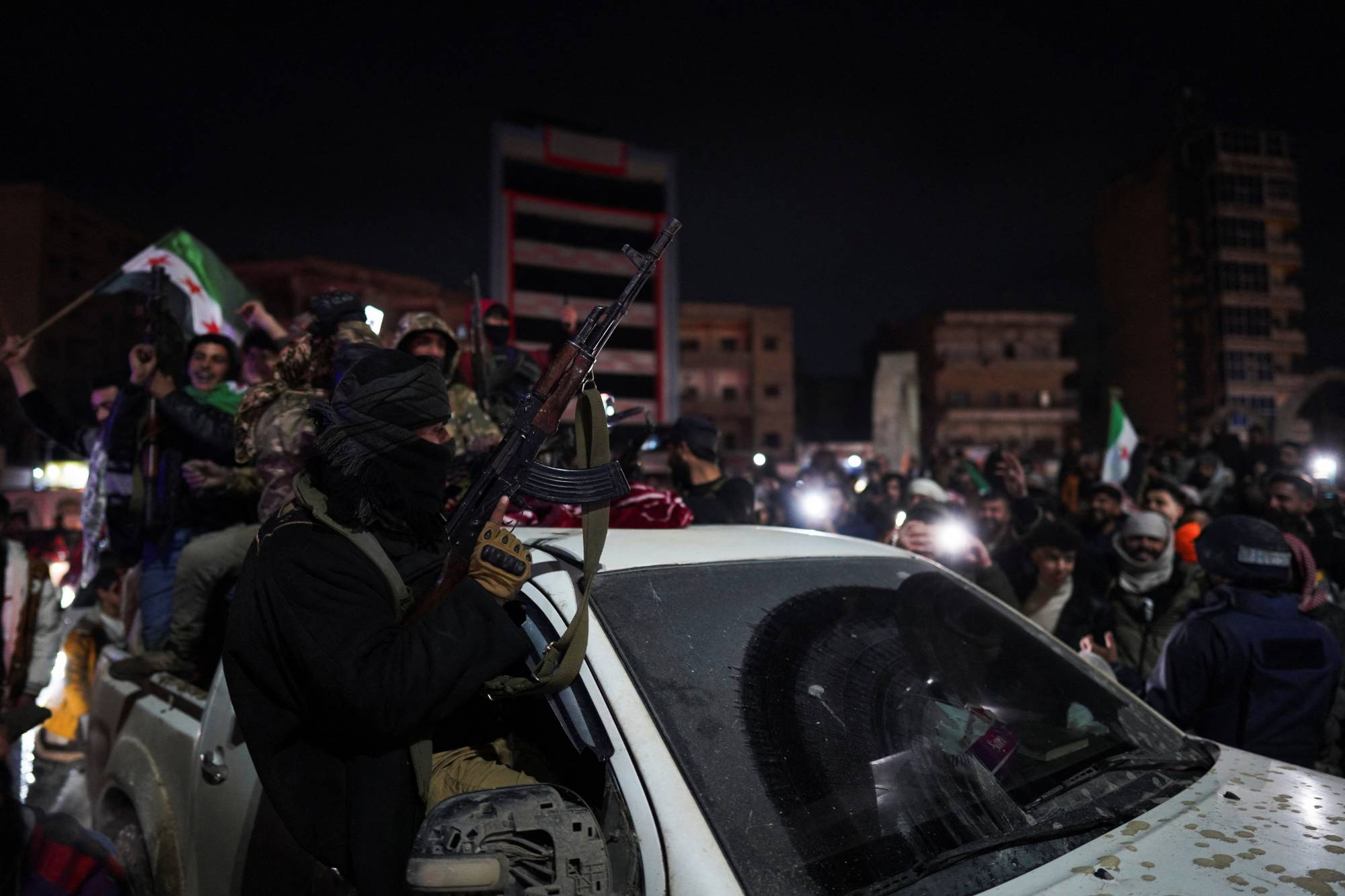 Suriye ordusu mensupları, Suriye Demokratik Güçleri’nin (SDG) çekilmesinin ardından Rakka’ya girişlerini kutluyor. (Reuters)