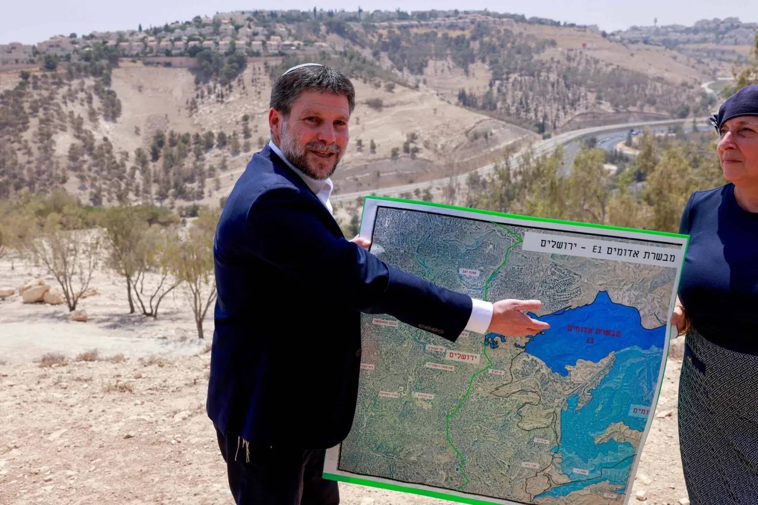 İsrail'in aşırı sağcı Maliye Bakanı Bezalel Smotrich, Batı Şeria'daki Ma'ale Adumim yerleşimini genişletme planına ilişkin bir haritayı incelerken (Arşiv - AFP)