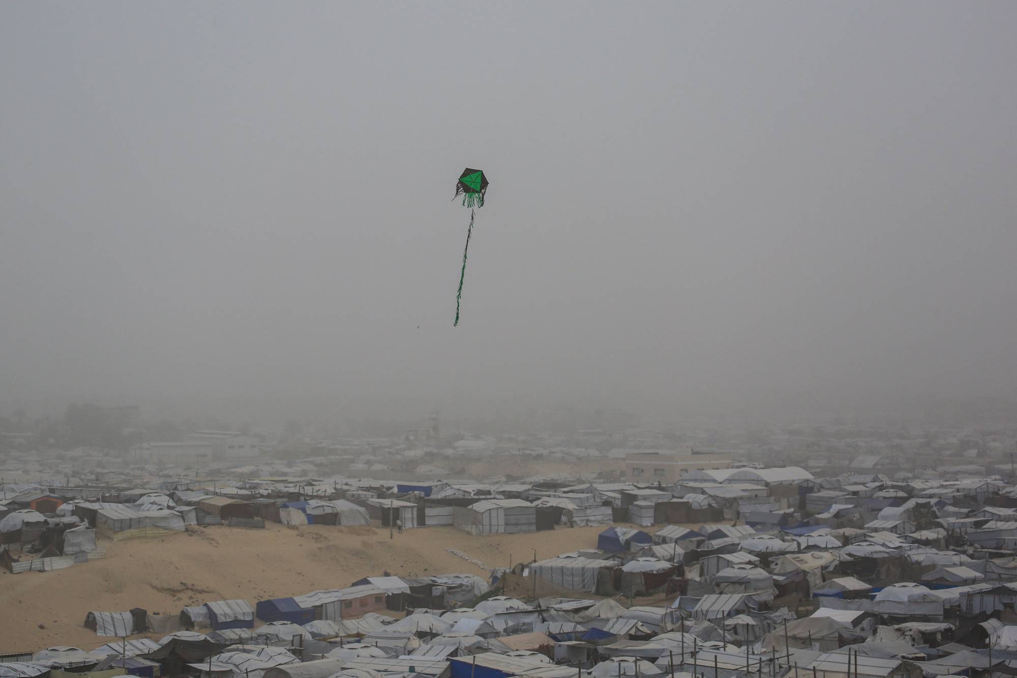  Gazze Şeridi’nin güneyindeki Han Yunus’ta bulunan bir mülteci kampının üzerinde uçan uçurtma, 14 Şubat 2026 (AFP)