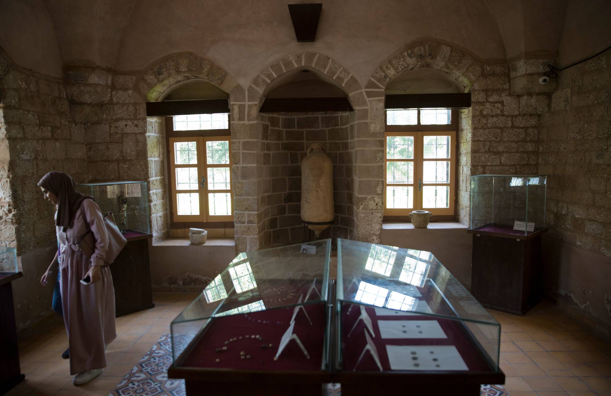  Bir ziyaretçi, İsrail'in Gazze şehrine yönelik savaşında hasar gören Gazze şehrindeki Paşa Sarayı müzesinde sergilenen eserleri inceliyor (AP)