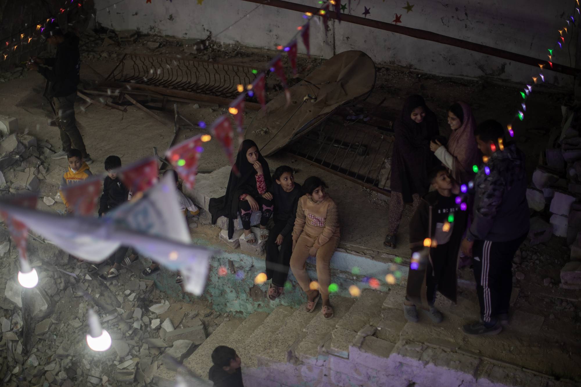 Filistinliler, Han Yunus'ta Ramazan ayını karşılamaya hazırlanırken yıkılan evlerinin kalıntıları üzerine süsler asıyor, (EPA)