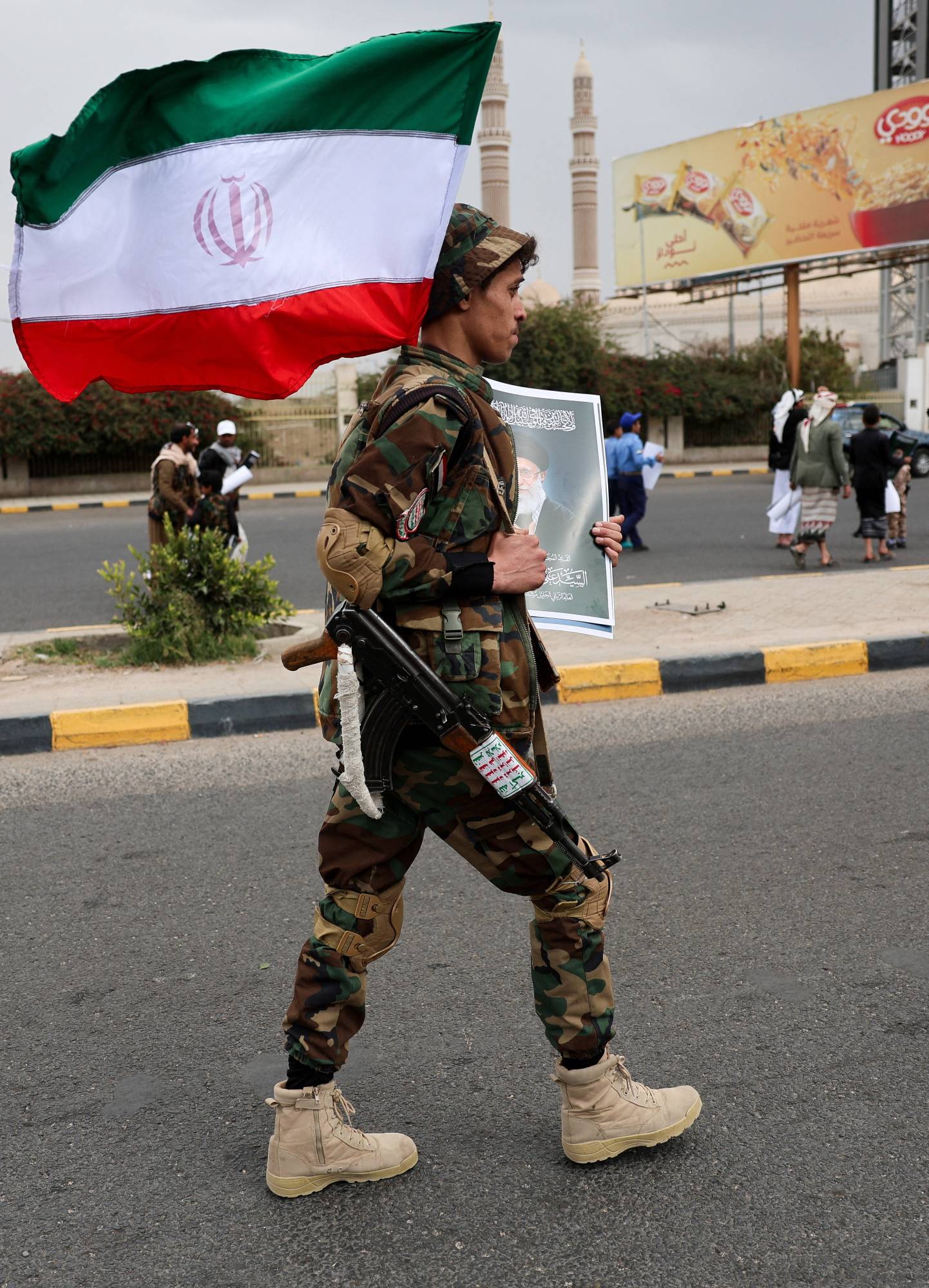  Sanaa'da bir Husi güvenlik görevlisi İran bayrağını tutuyor (Reuters)