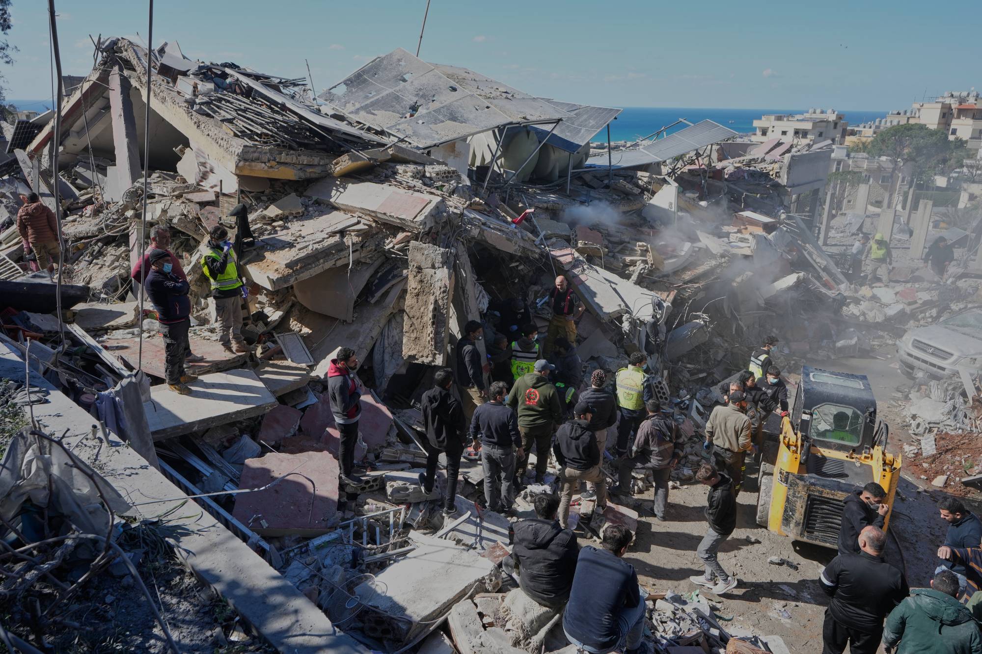 Yardım görevlileri, Lübnan'ın güneyindeki Gaziye kasabasında İsrail bombardımanı sonucu hasar gören bir binada kurbanları arıyor (AP)